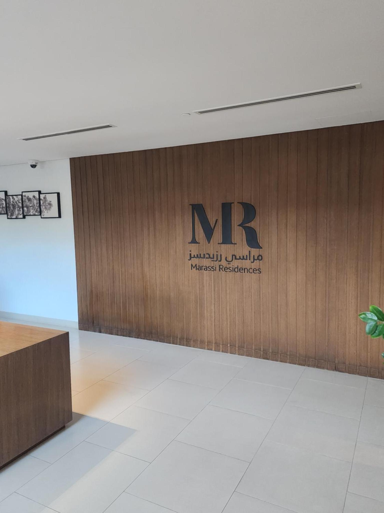 a wooden wall with a sign on it in a building at Luxury 2BR with Private Garden Marassi Living in Rayyā +51 photos
