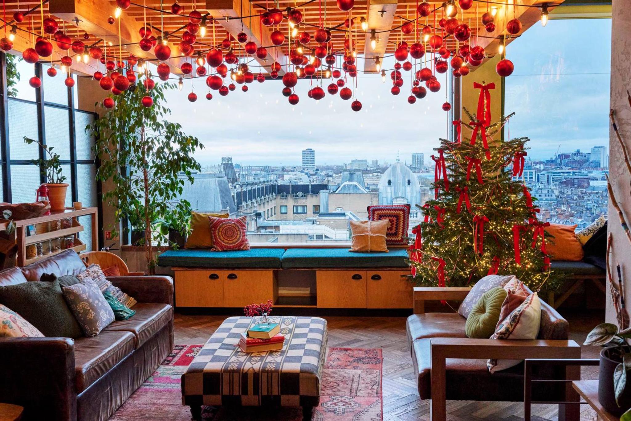 a living room with a christmas tree and a large window at Treehouse Hotel London in London