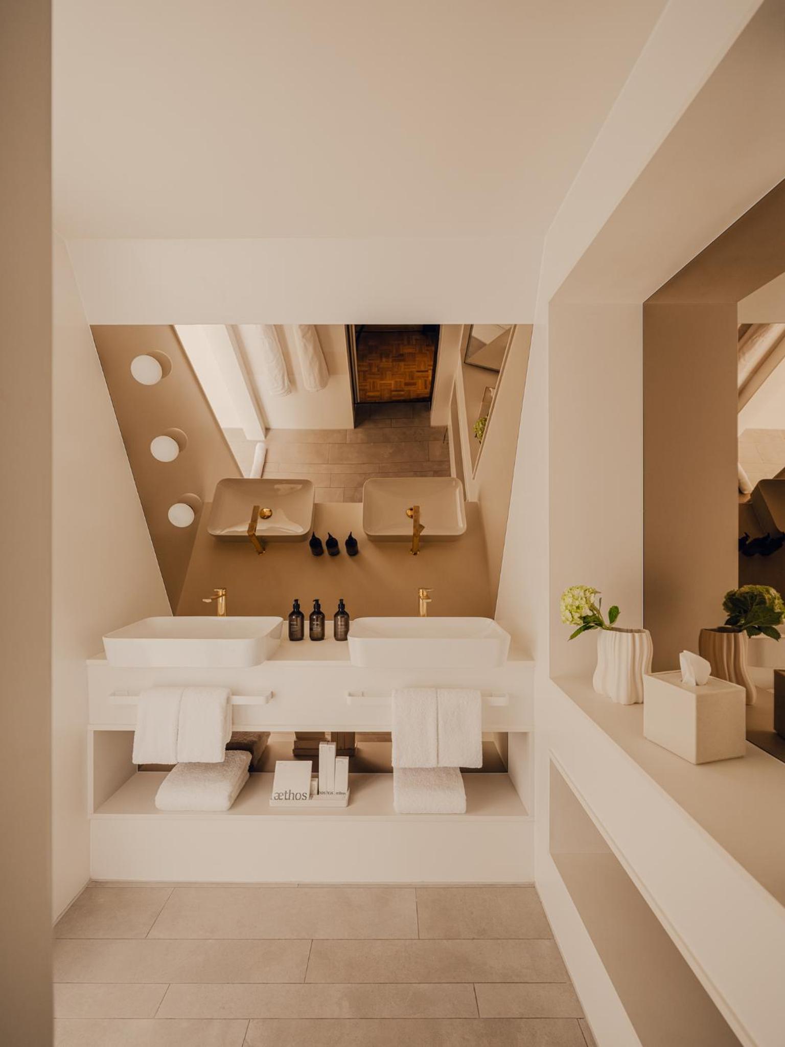 a bathroom with two sinks and a staircase at Aethos Hotel London Shoreditch in London