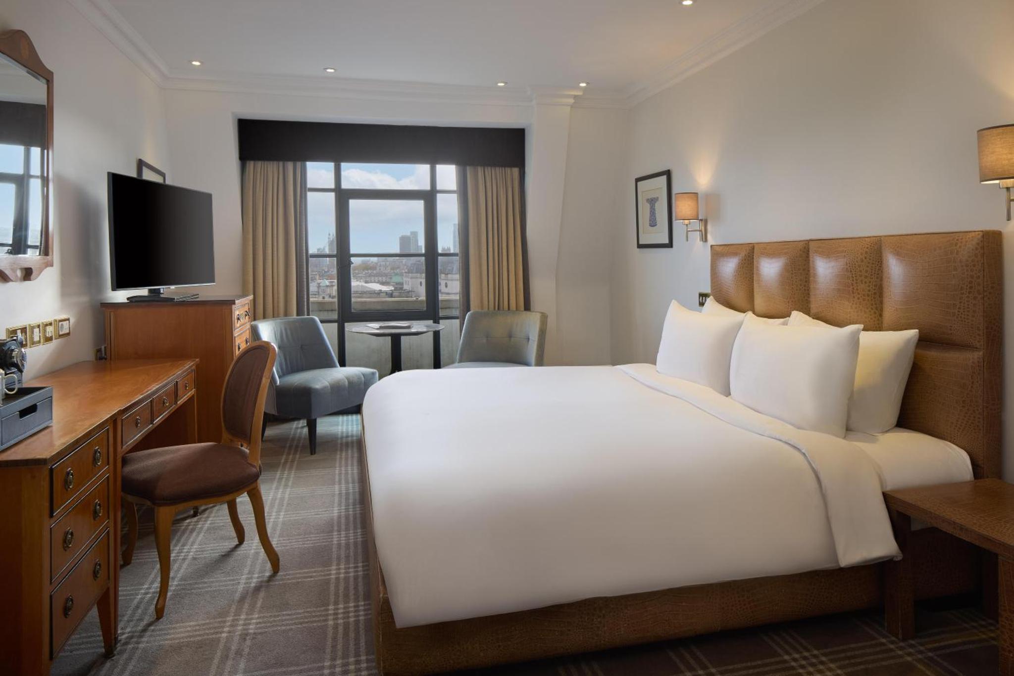 a hotel room with a large bed and a desk at Radisson Blu Hotel, London Leicester Square in London