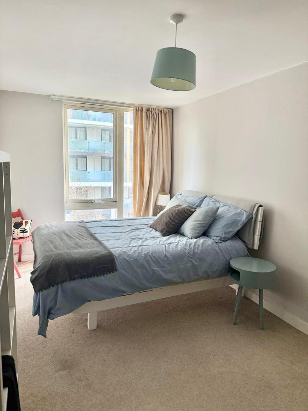 a bedroom with a bed and a window at Spacious Flat Between Stockwell & Brixton in London