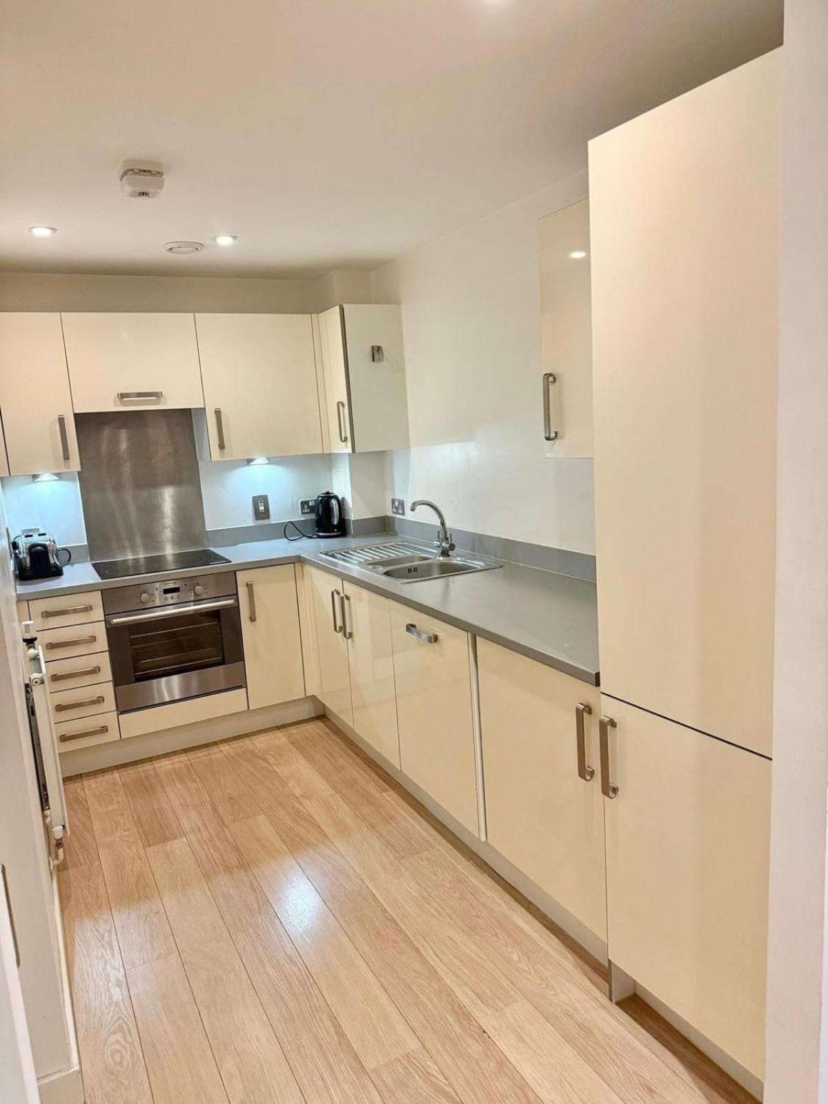 a kitchen with white cabinets and stainless steel appliances at Spacious Flat Between Stockwell & Brixton in London