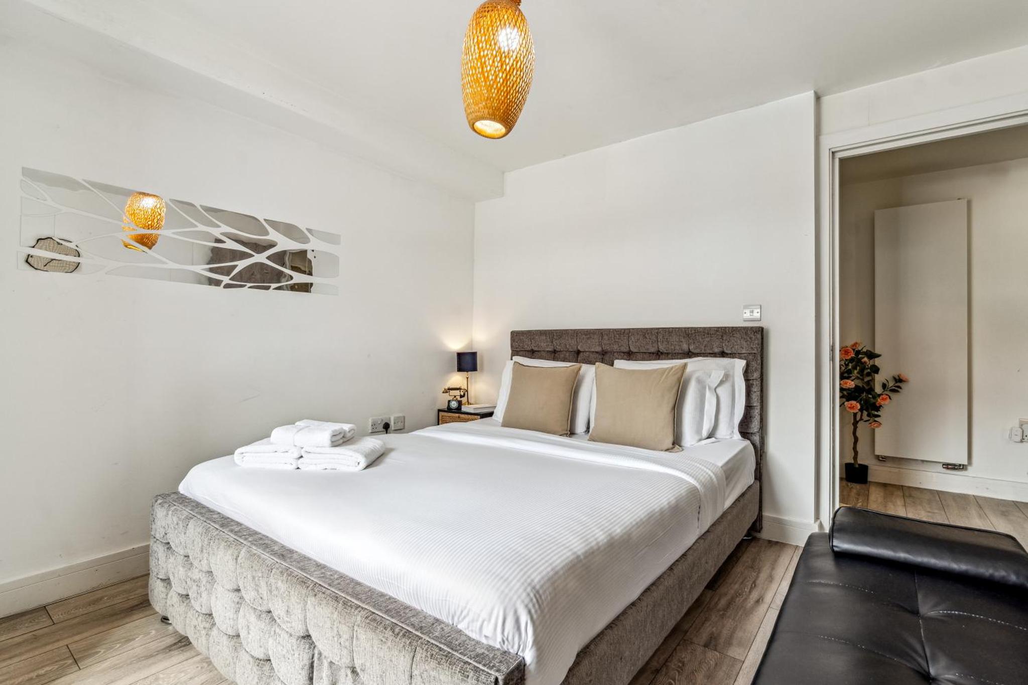 a bedroom with a large bed with white sheets at Keyhol Short Stay I Trendy Flat I Bricklane Market in London