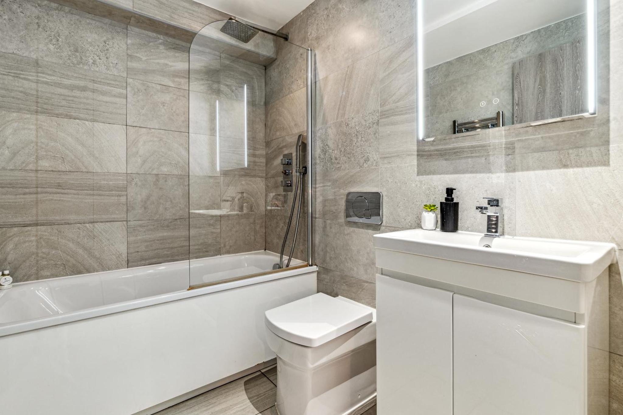 a bathroom with a sink and a toilet and a bath tub at Keyhol Short Stay I Trendy Flat I Bricklane Market in London