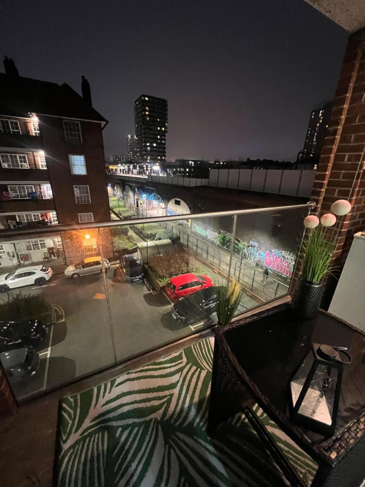 a balcony with a view of a parking lot at night at Tower Bridge Luxury Apartment with Balcony in London