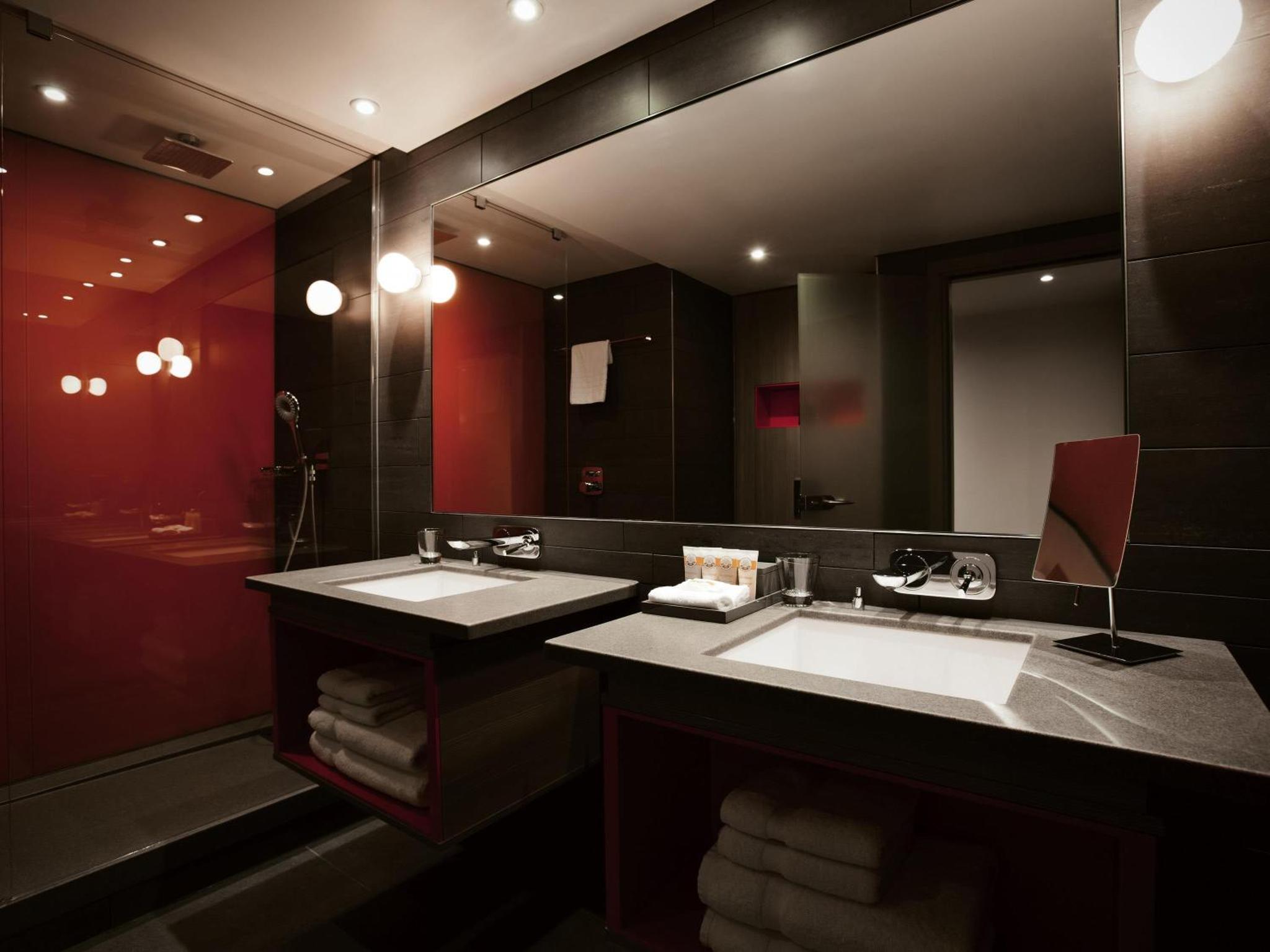 a bathroom with two sinks and a large mirror at Pullman London St Pancras in London