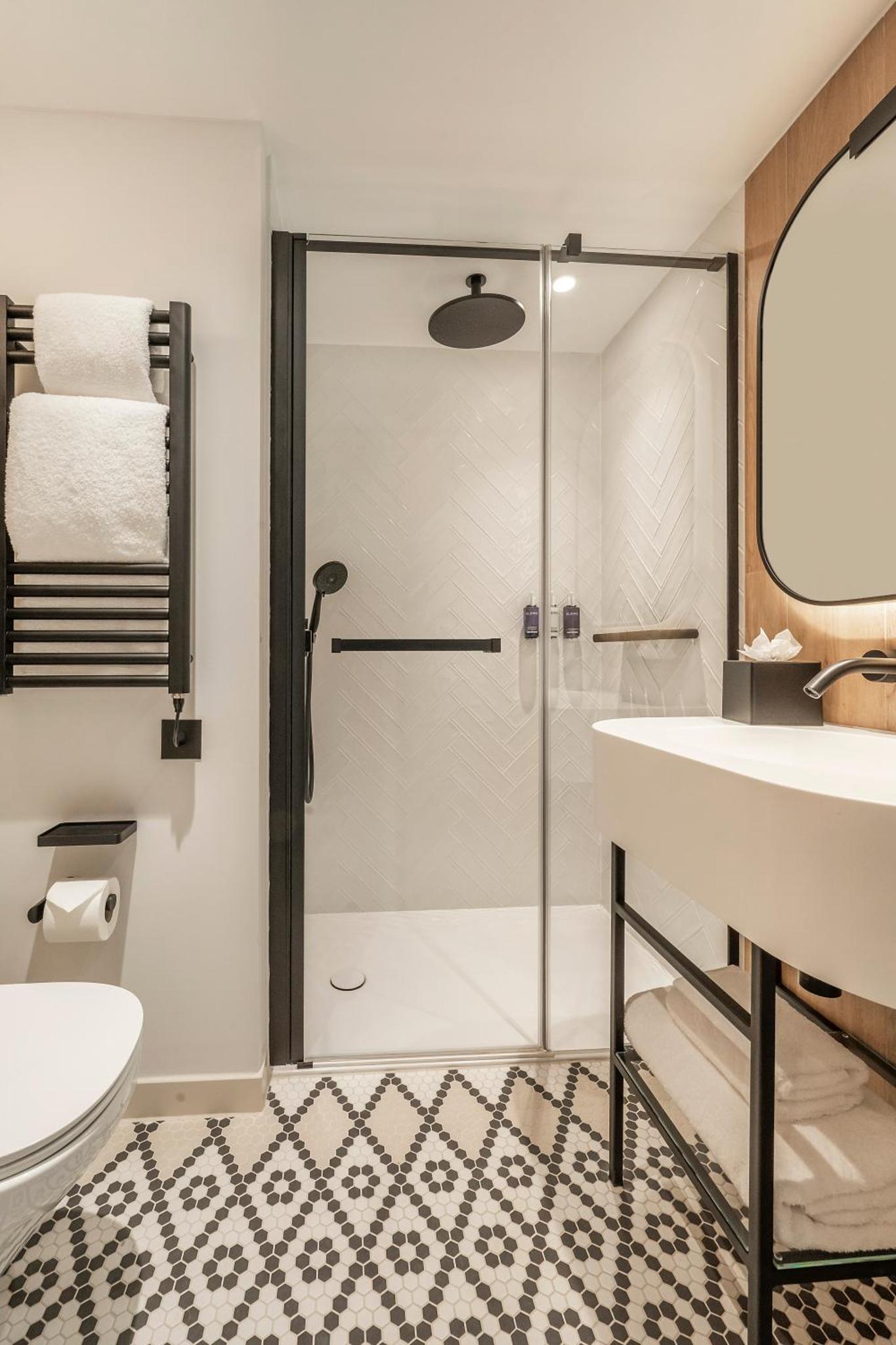 a bathroom with a shower and a sink at Dorsett Hotel Canary Wharf in London