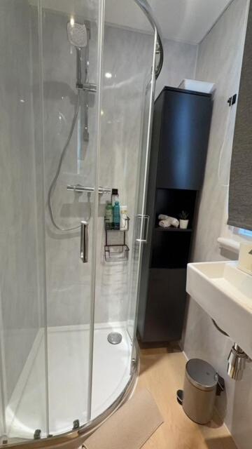 a shower with a glass door in a bathroom at Cosy central studio close to local attractions in London