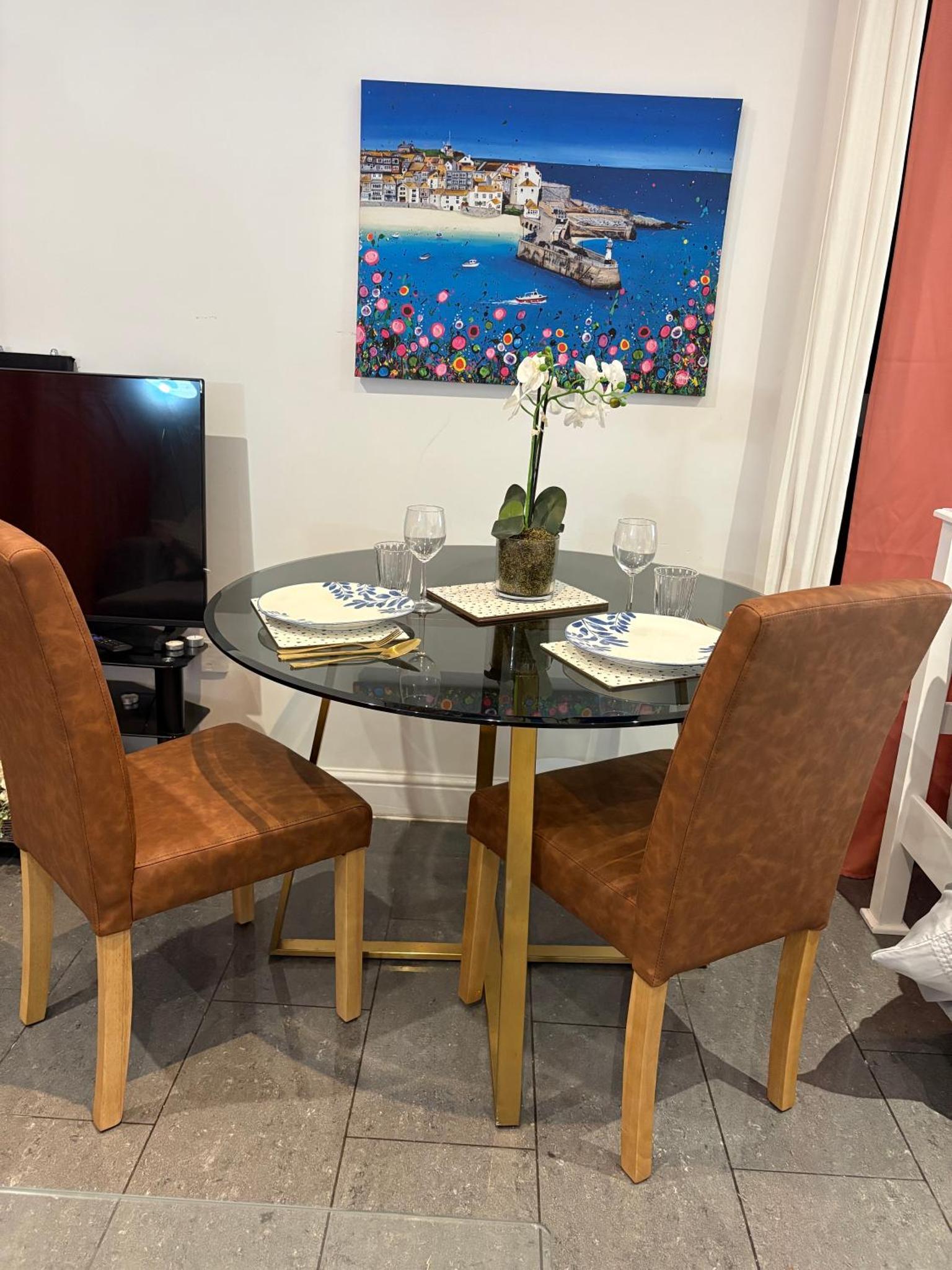 a dining room with a glass table and chairs at Tower Bridge Luxury Apartment with Balcony in London