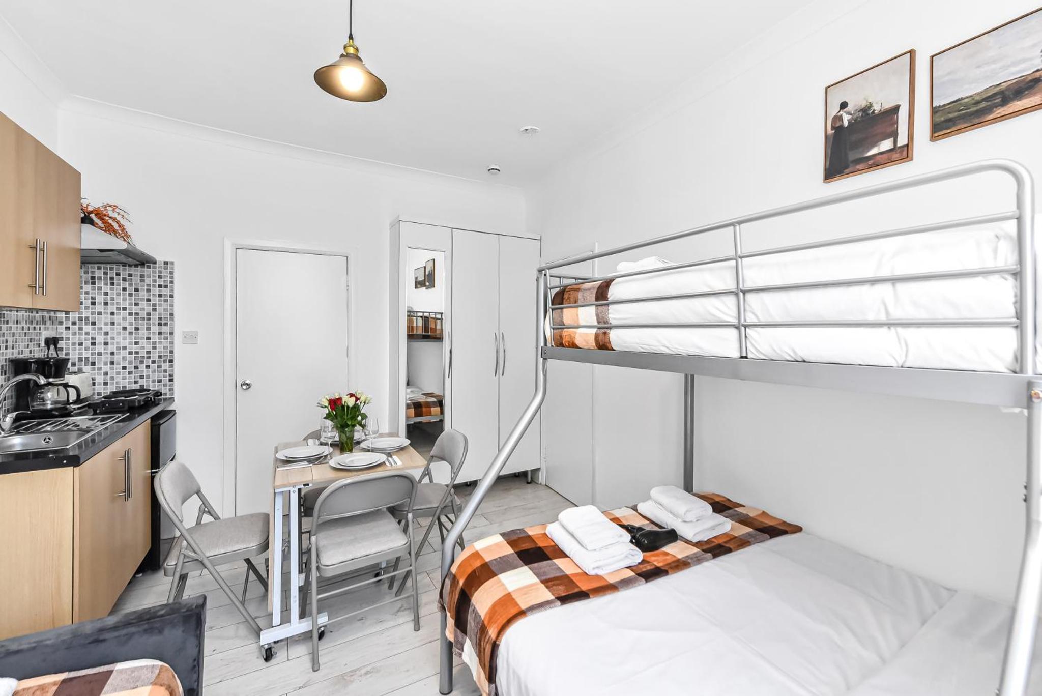 a bedroom with a bunk bed and a kitchen at Beautiful Stay Camden, 4 Minutes to King s Cross Station in London