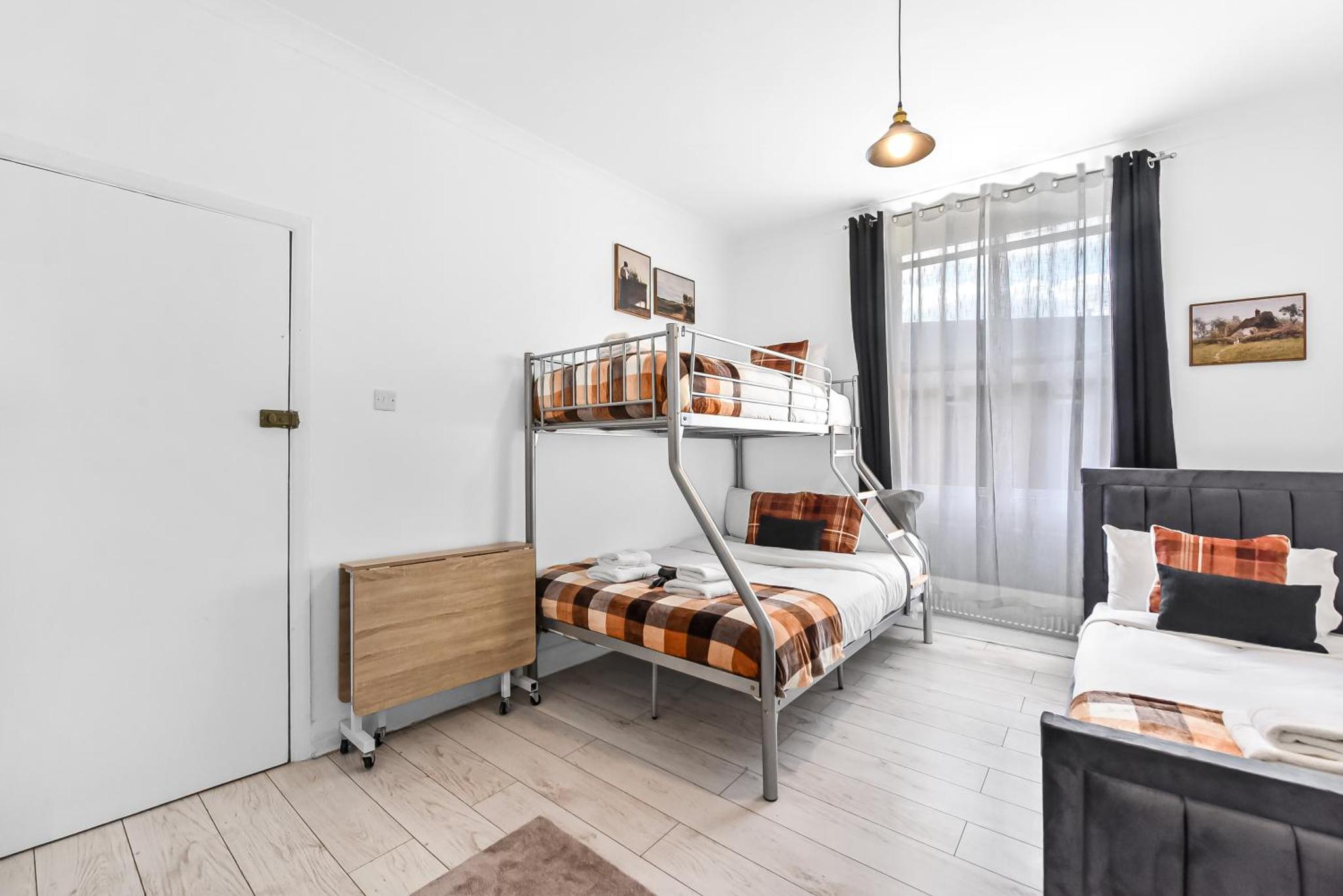 a bedroom with a bunk bed and a couch at Beautiful Stay Camden, 4 Minutes to King s Cross Station in London