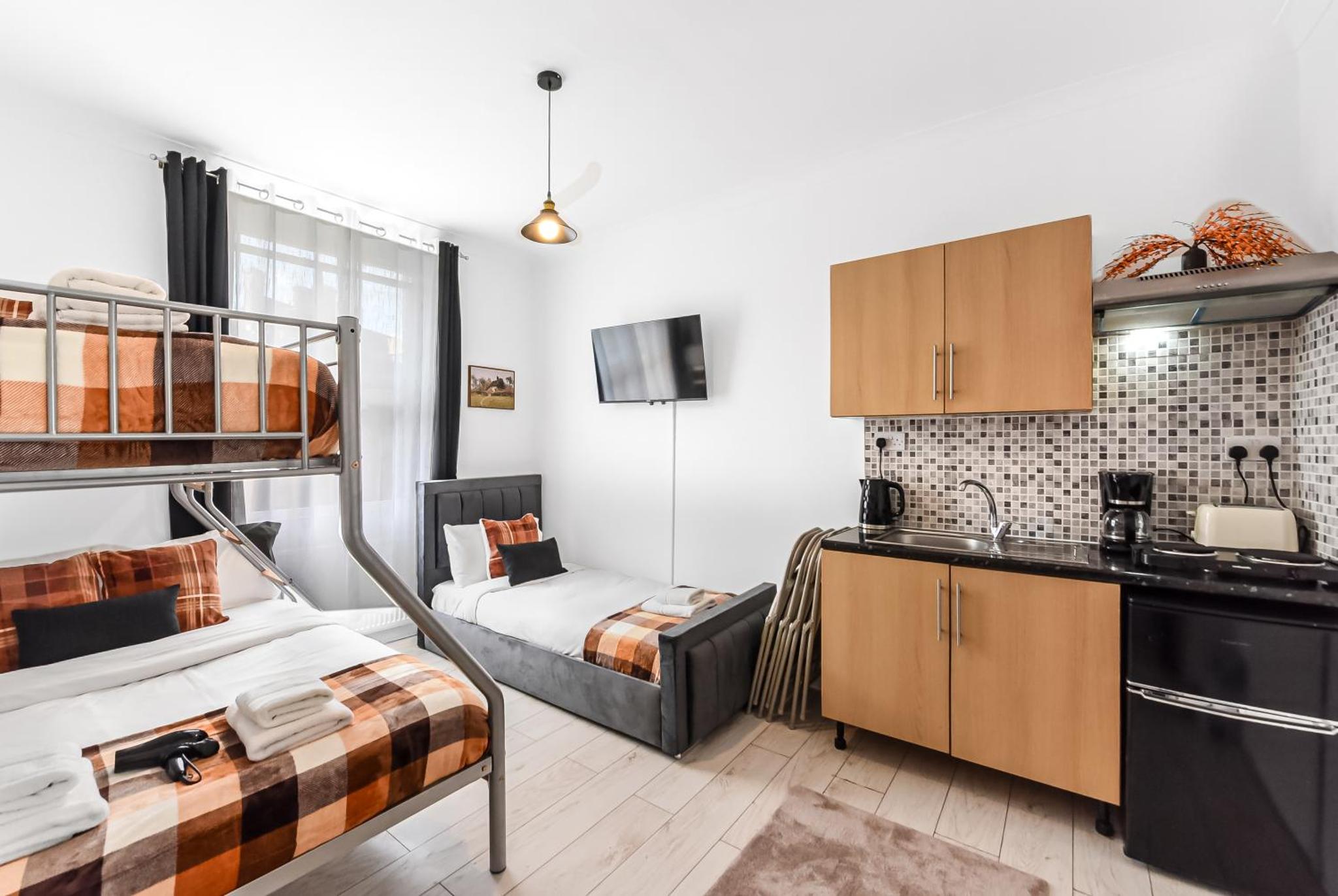 a small room with two bunk beds and a kitchen at Beautiful Stay Camden, 4 Minutes to King s Cross Station in London