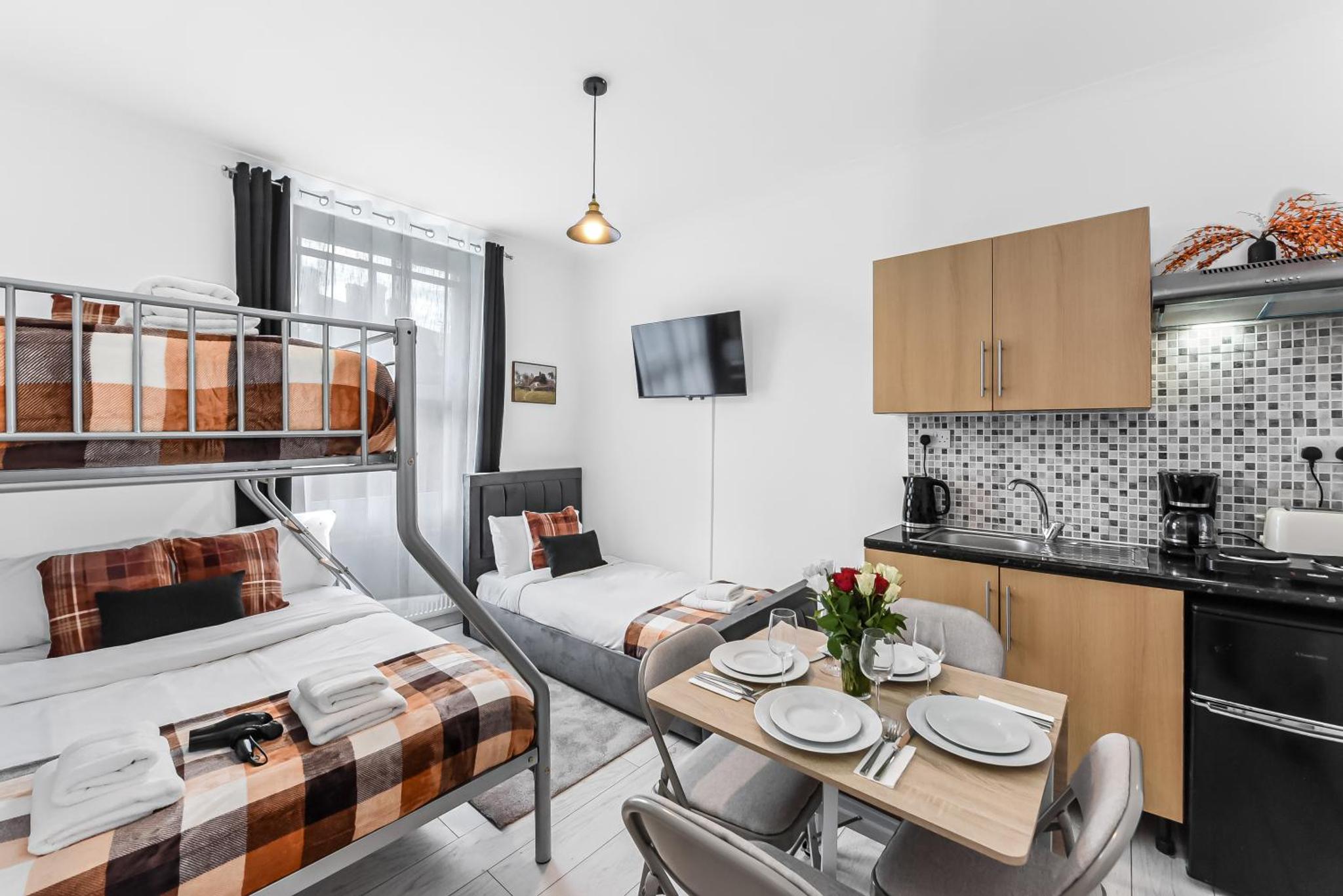 a small apartment with a bed and a table and chairs at Beautiful Stay Camden, 4 Minutes to King s Cross Station in London