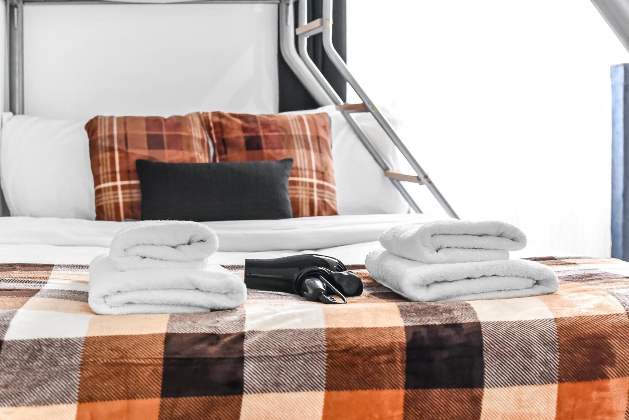 a bed with towels on top of it at Beautiful Stay Camden, 4 Minutes to King s Cross Station in London