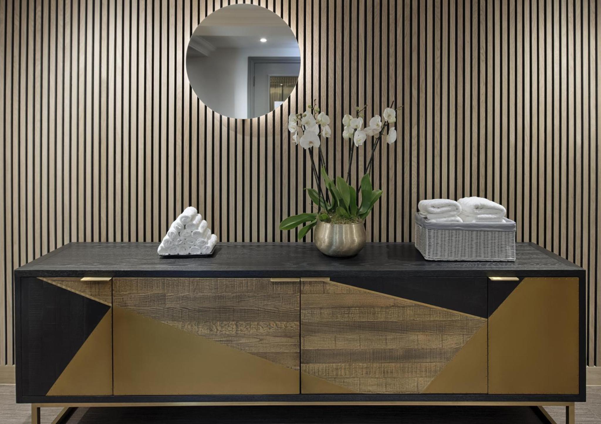 a dressing table with a mirror and a vase of flowers at Hyatt Regency London - The Churchill in London
