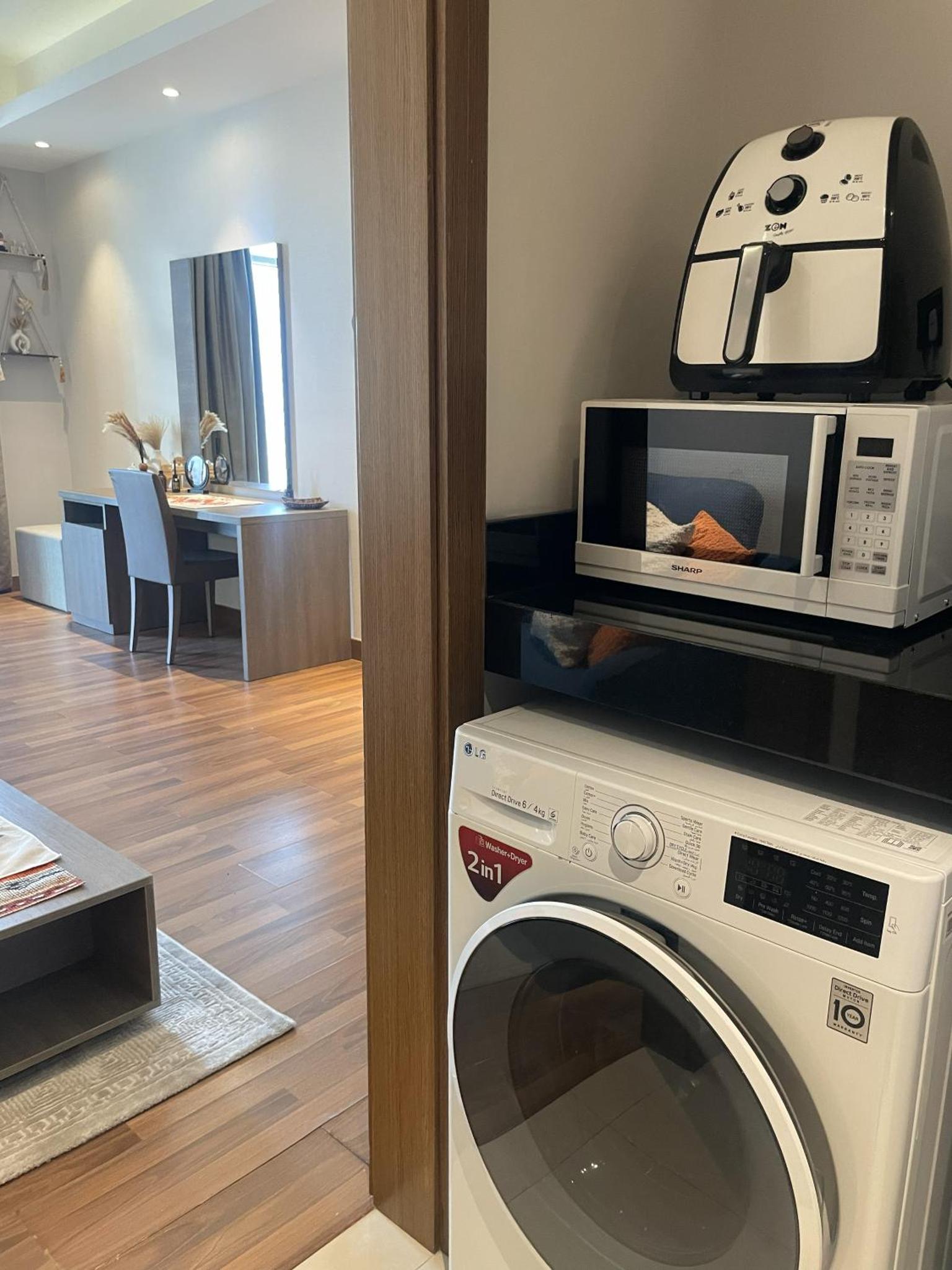 a microwave sitting on top of a washing machine at Boho Cozy Escape in Quiet Neighborhood in Sanābis