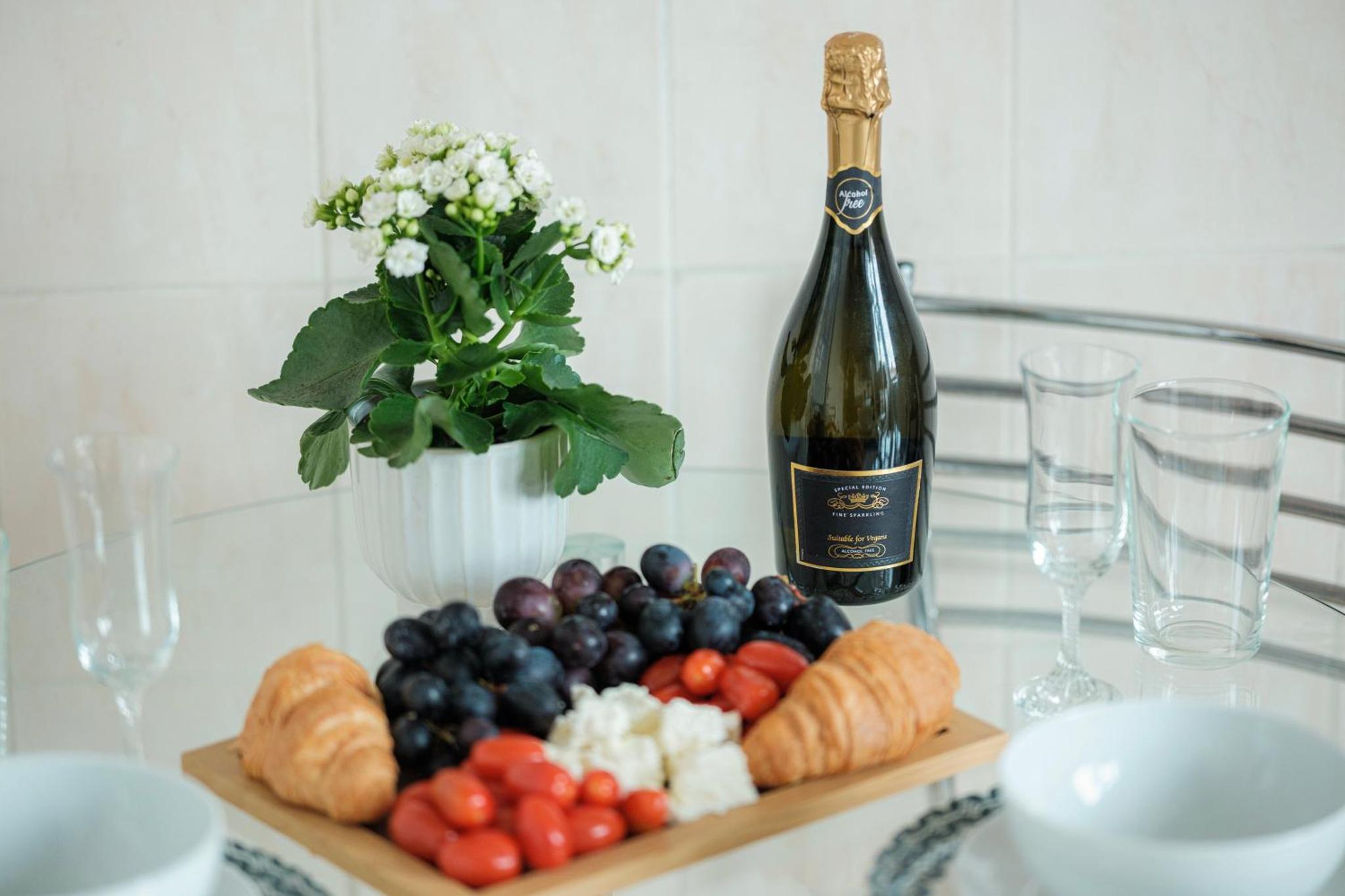 a bottle of wine next to a plate of food at 3 of 5 Room Cozy, spacious and modern in Camden Town in London