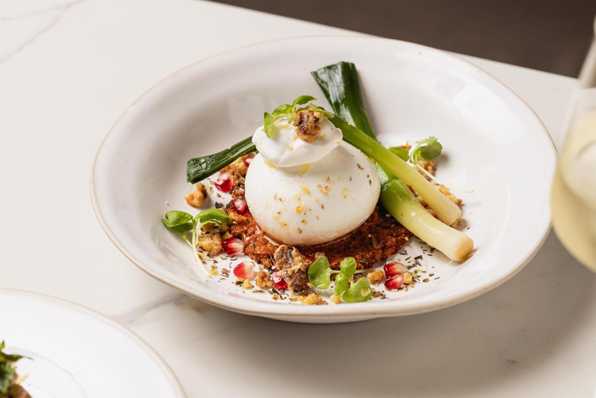 a white bowl of food with a poached egg on top at Holmes Hotel London in London