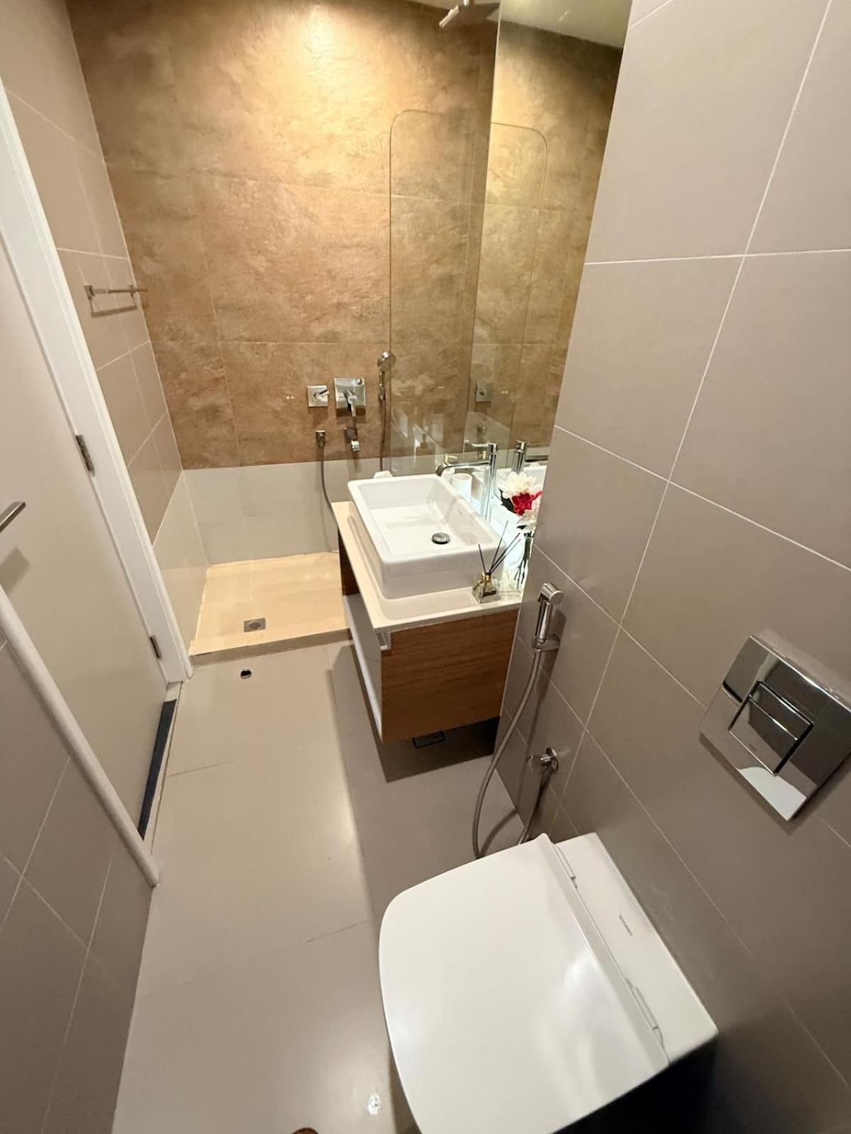 a bathroom with a white toilet and a sink at A lavishly furnished one bedroom flat at Marassi in Muharraq