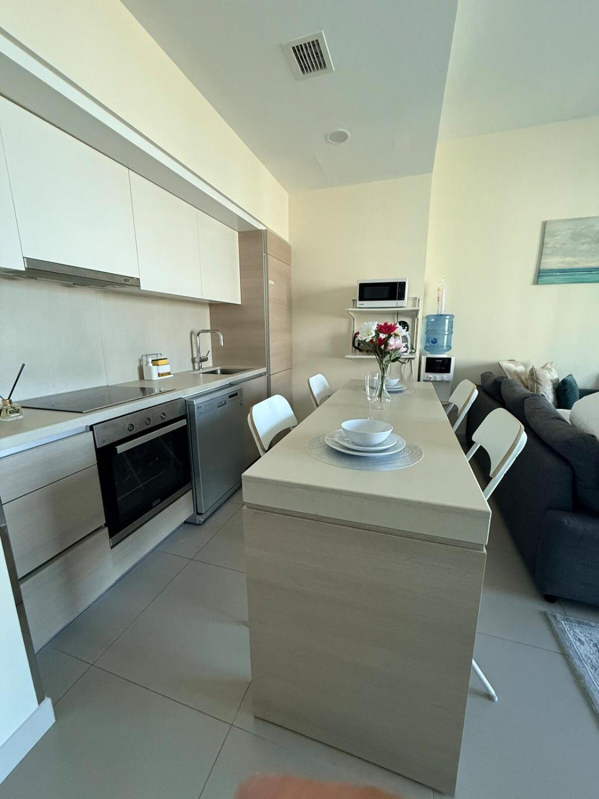 a kitchen and living room with a table and a couch at A lavishly furnished one bedroom flat at Marassi in Muharraq