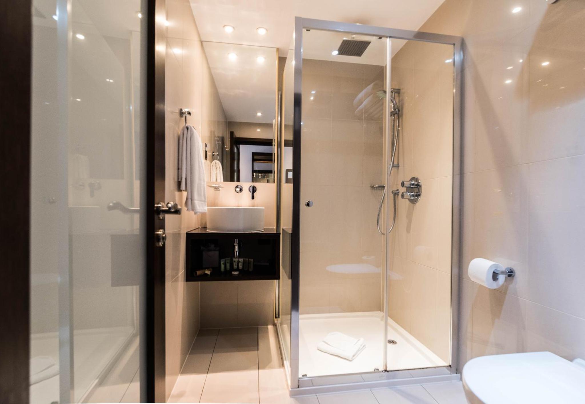 a bathroom with a shower and a sink at Park Avenue Baker Street in London