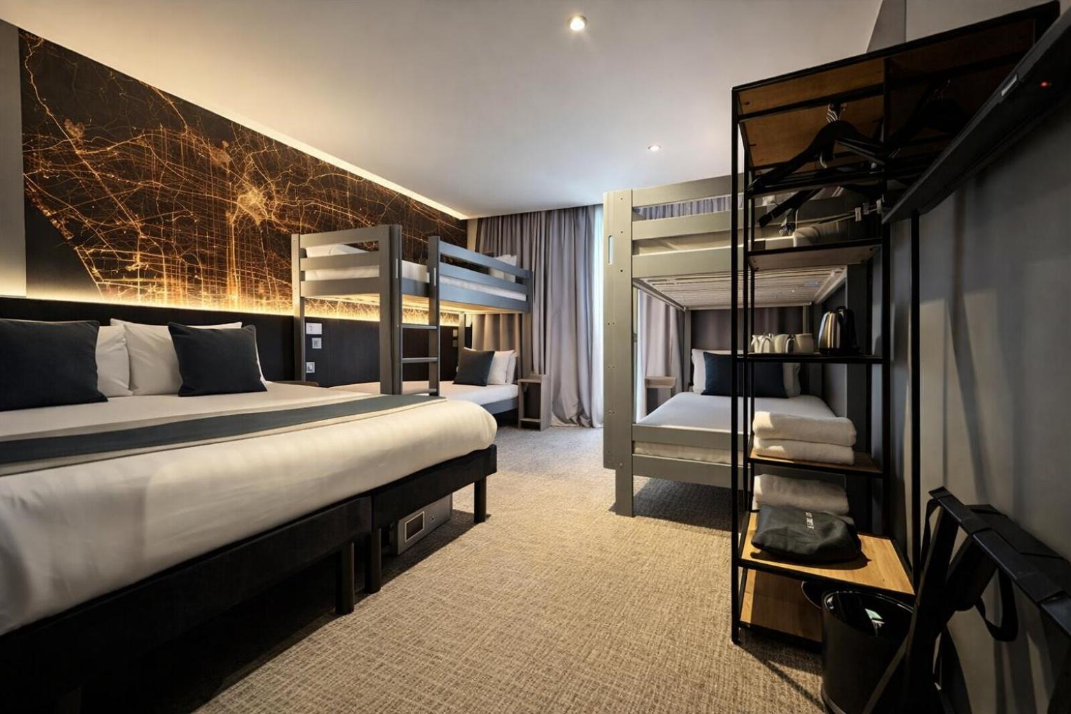 a hotel room with a bed and bunk beds at Heeton Concept Hotel – Luma Hammersmith in London