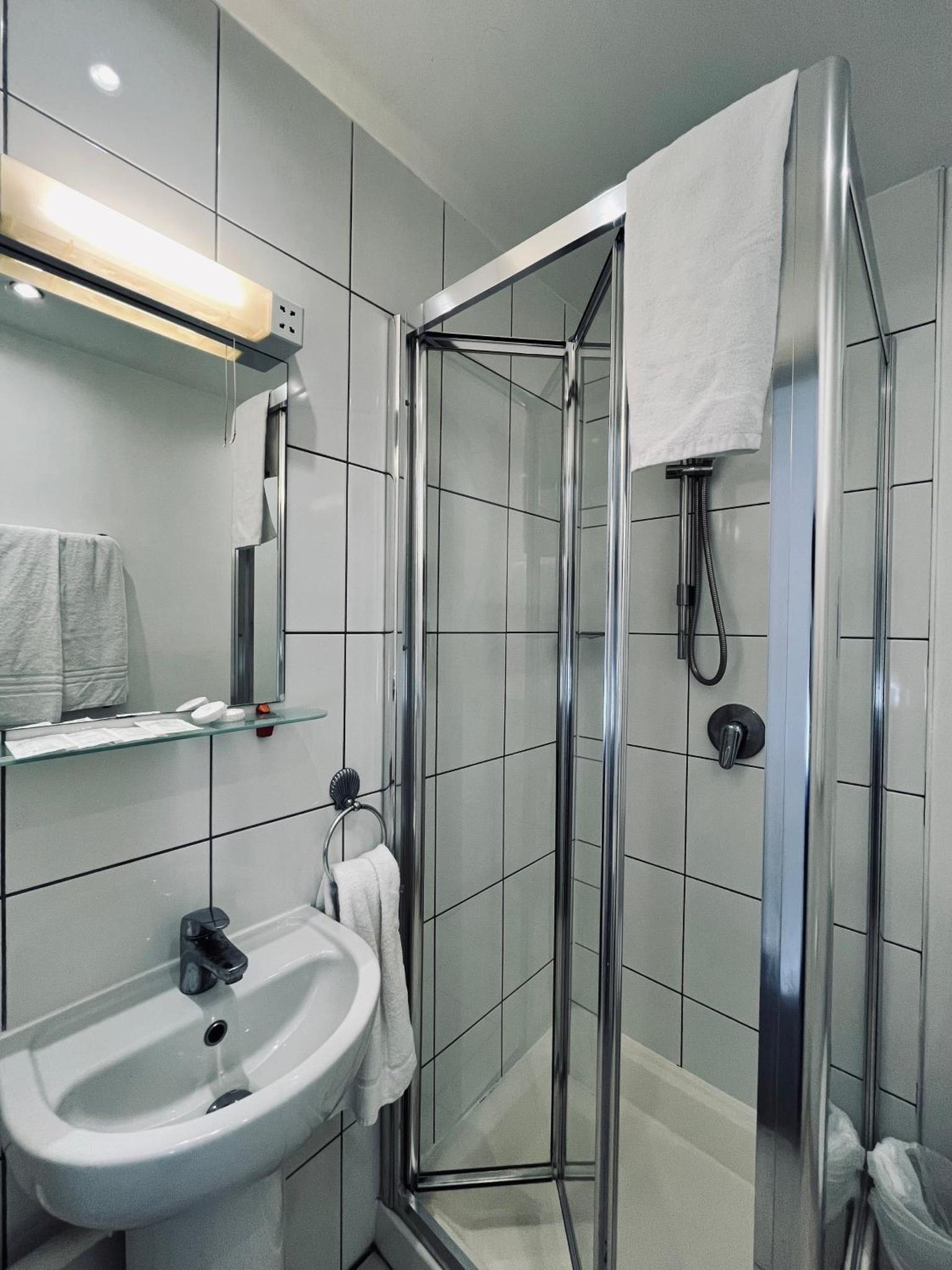 a bathroom with a shower and a sink at Arriva Hotel in London