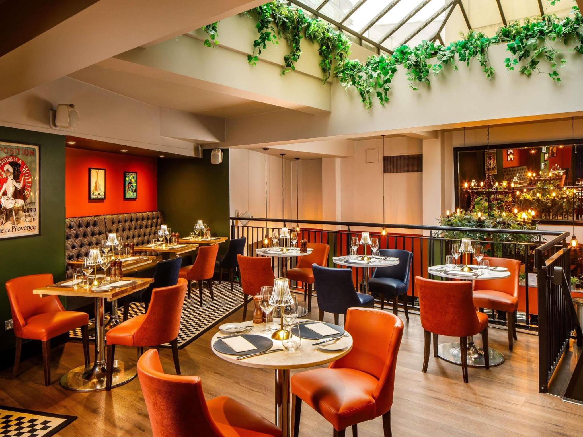 a restaurant with tables and chairs in a room at Mercure London Bankside in London