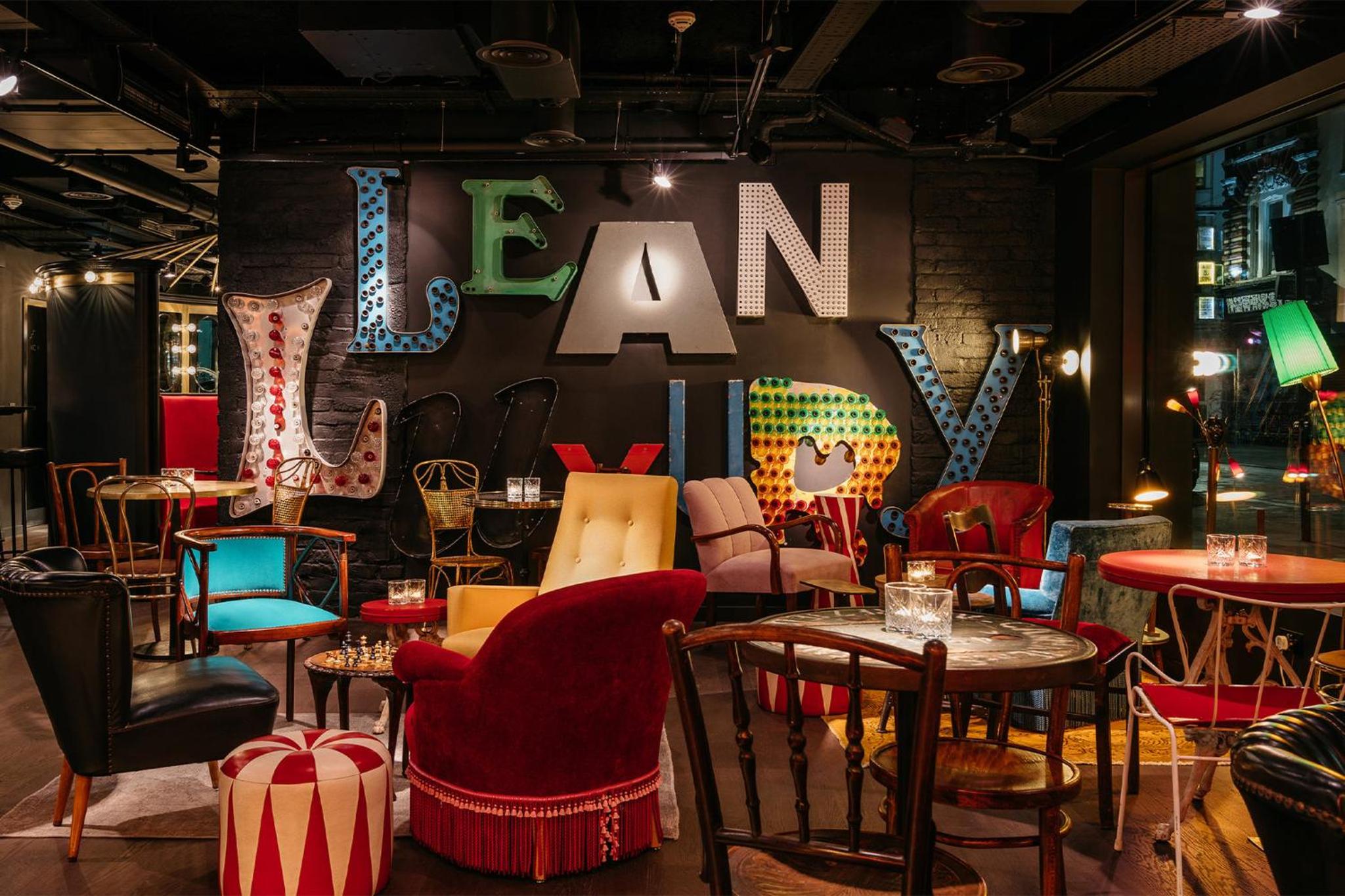 a restaurant with tables and chairs and a sign that says learn at Ruby Lucy Hotel London by IHG in London