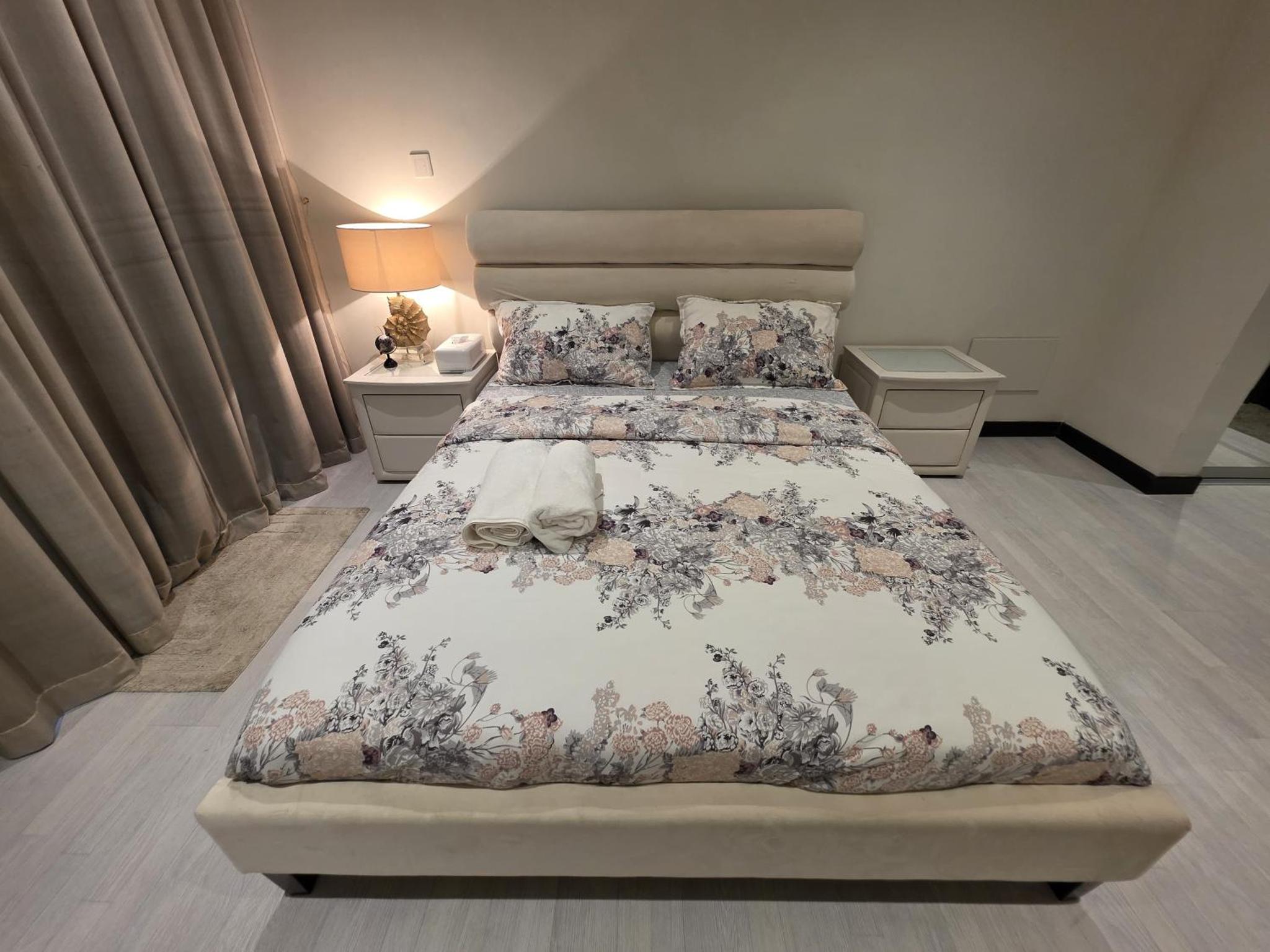 a bedroom with a large bed with a floral bedspread at Stunning Sea View 3BR Duplex in Reef Island in Sanābis +53 photos