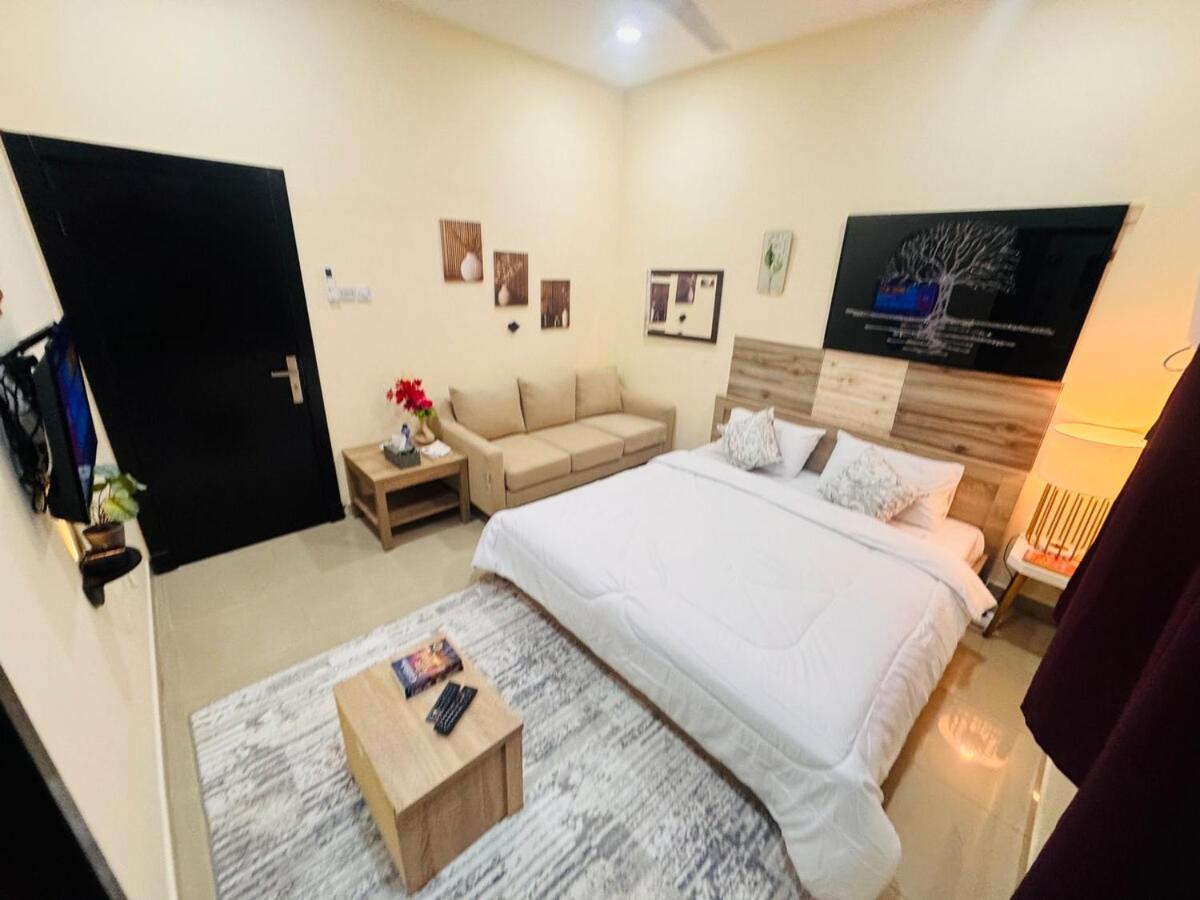 a bedroom with a large white bed and a couch at Luxurious Cozy Studio Flat Message whatsap below for bookings in Sanābis +27 photos