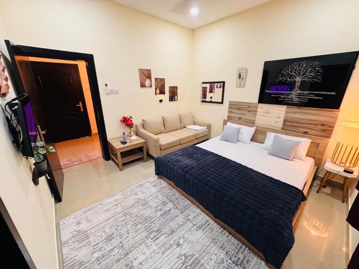 a bedroom with a bed and a living room with a couch at Luxurious Cozy Studio Flat Message whatsap below for bookings in Sanābis