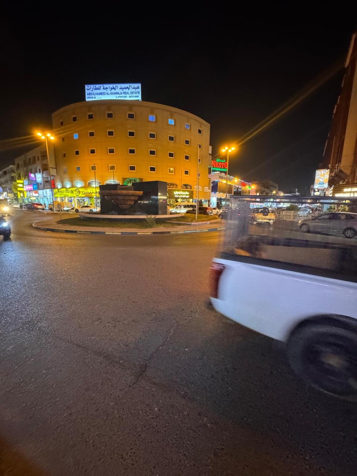 a white car driving down a street at night at Luxurious Cozy Studio Flat Message whatsap below for bookings in Sanābis