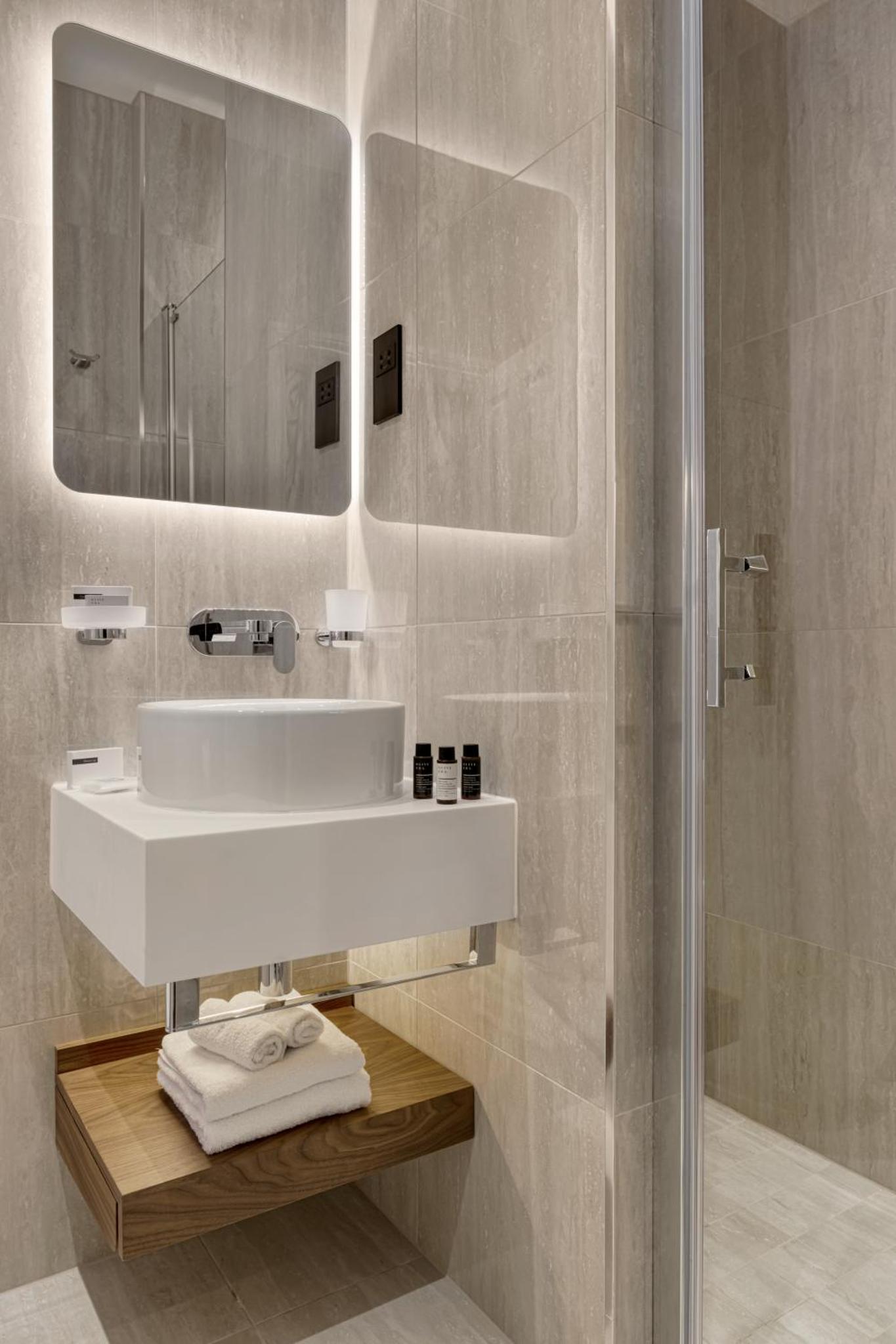 a bathroom with a sink and a shower at The Queens Gate Hotel in London