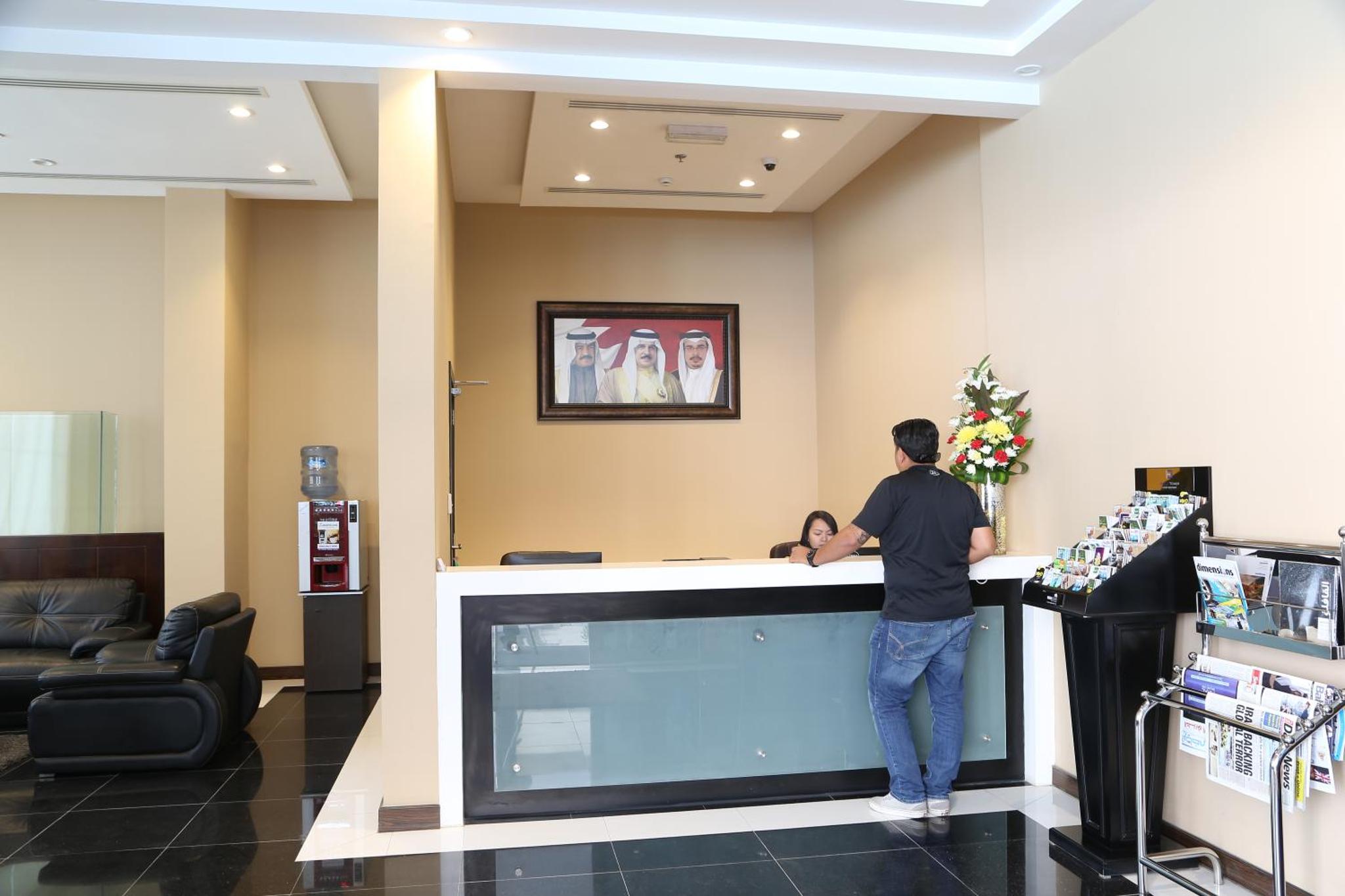 a man standing at a counter in a waiting room at Belle Tower Apartments in Manama +34 photos