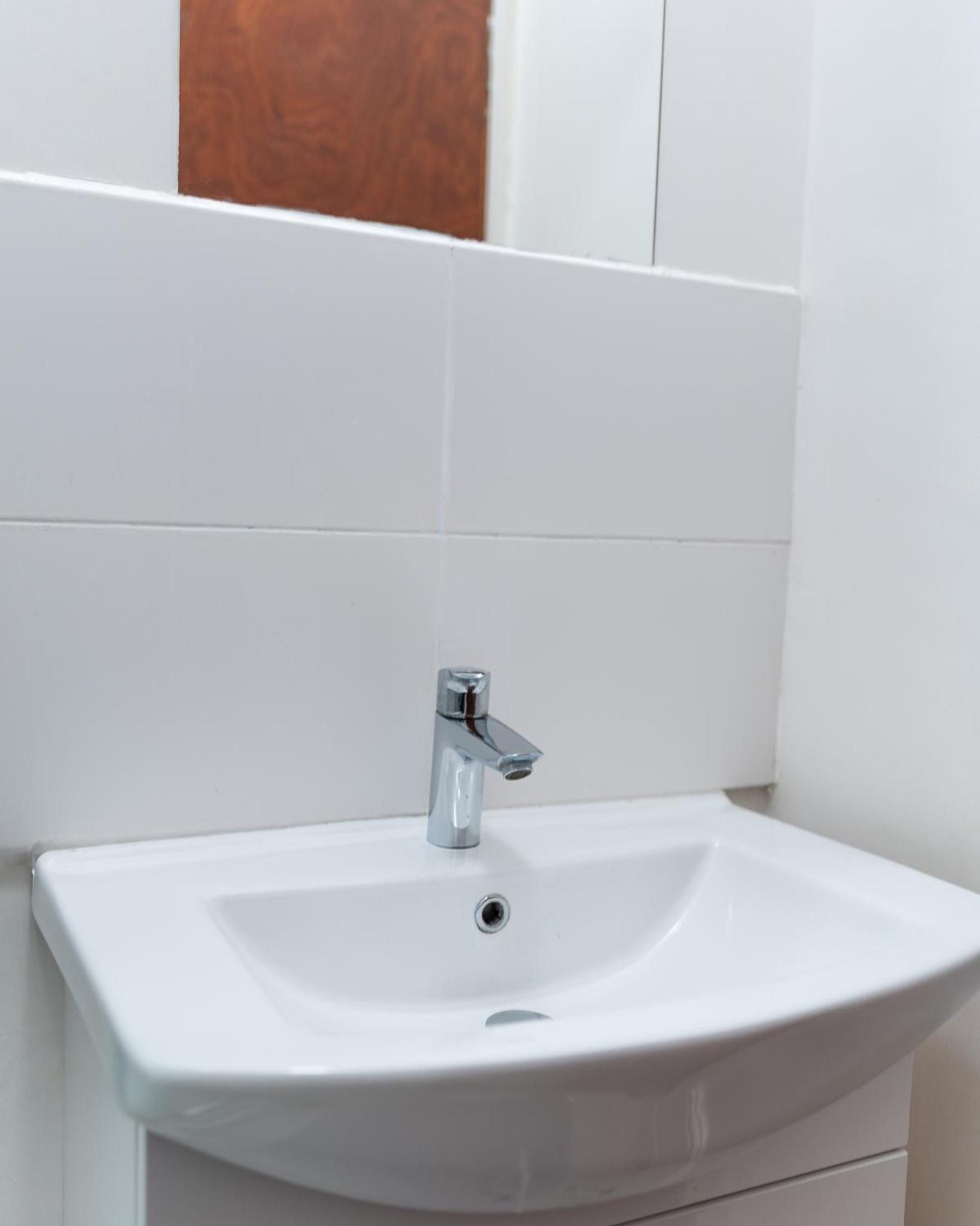 a white sink in a white bathroom at Studio apartment next to Highgate tube station in London