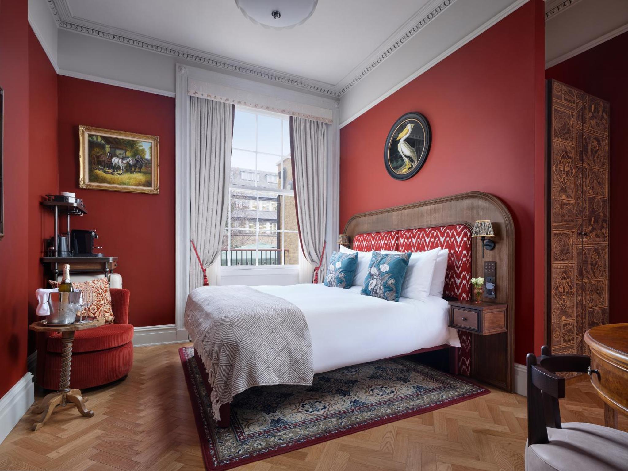 a bedroom with red walls and a bed and a window at Bertrand's Townhouse in London +39 photos