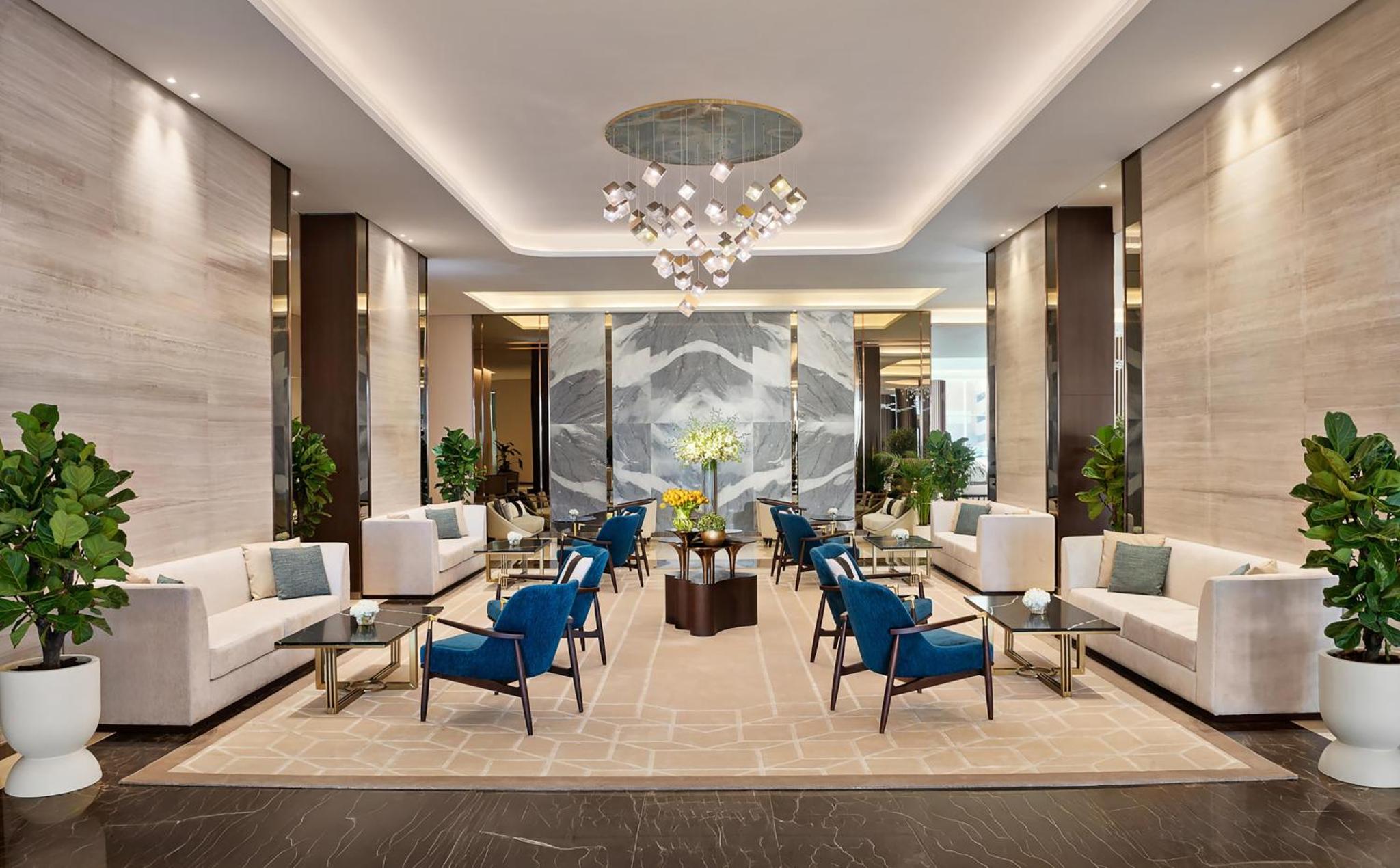 a lobby with couches and chairs and a chandelier at Hilton Bahrain City Centre Hotel & Residences in Manama +139 photos