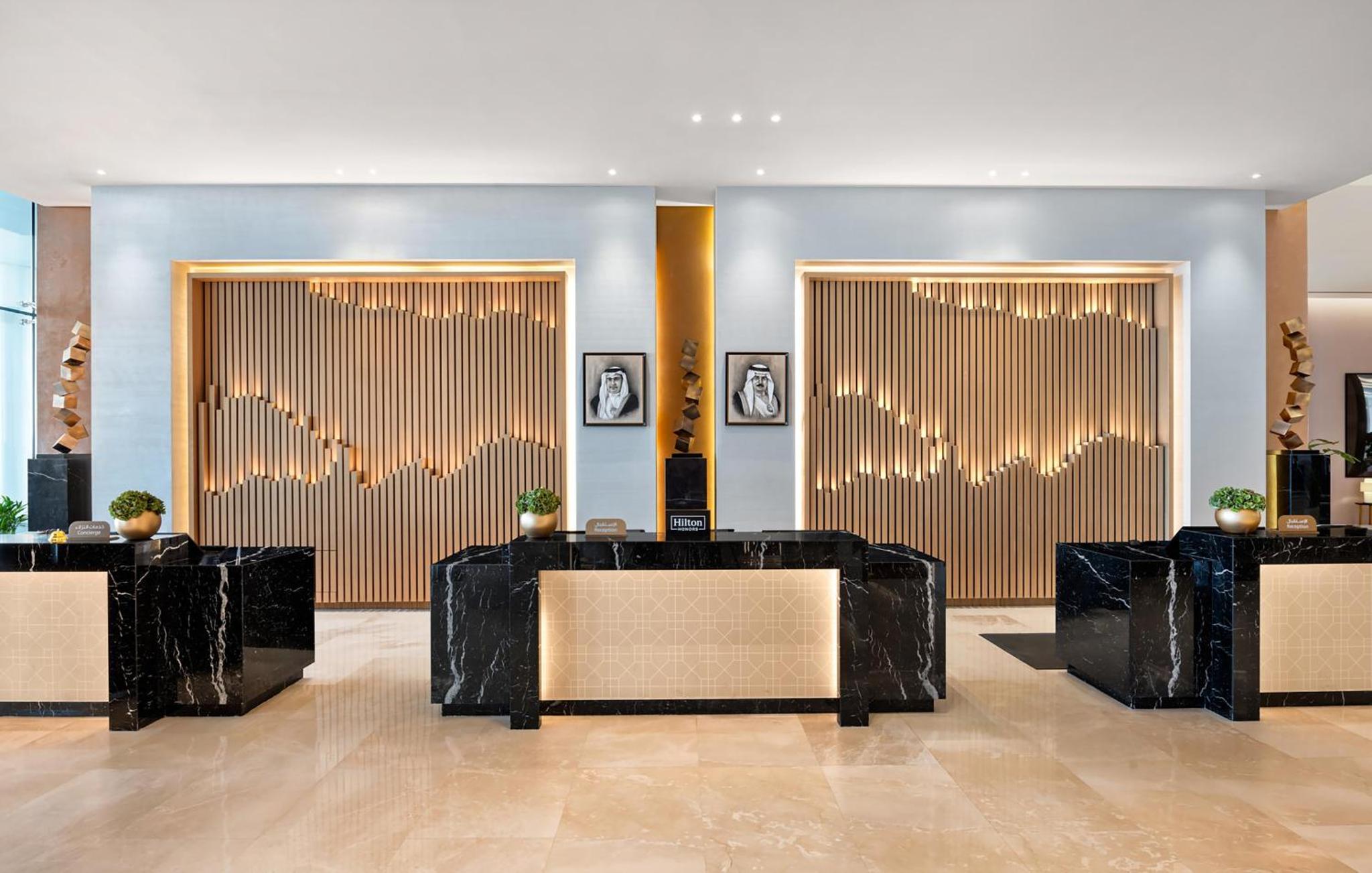 a lobby with black and gold walls and tables at Hilton Bahrain City Centre Hotel & Residences in Manama