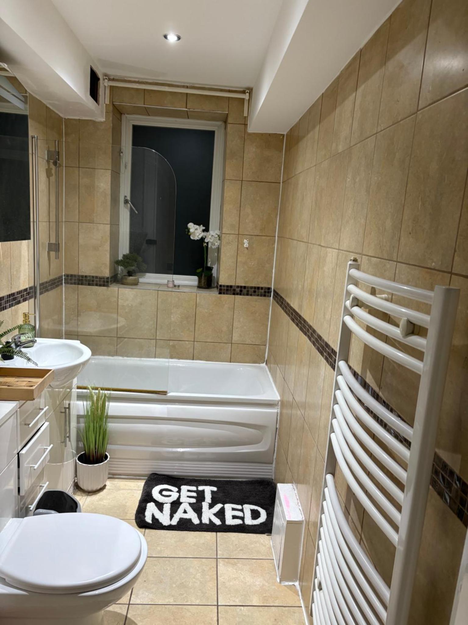a bathroom with a tub and a toilet and a sink at Tower Bridge Luxury Apartment with Balcony in London