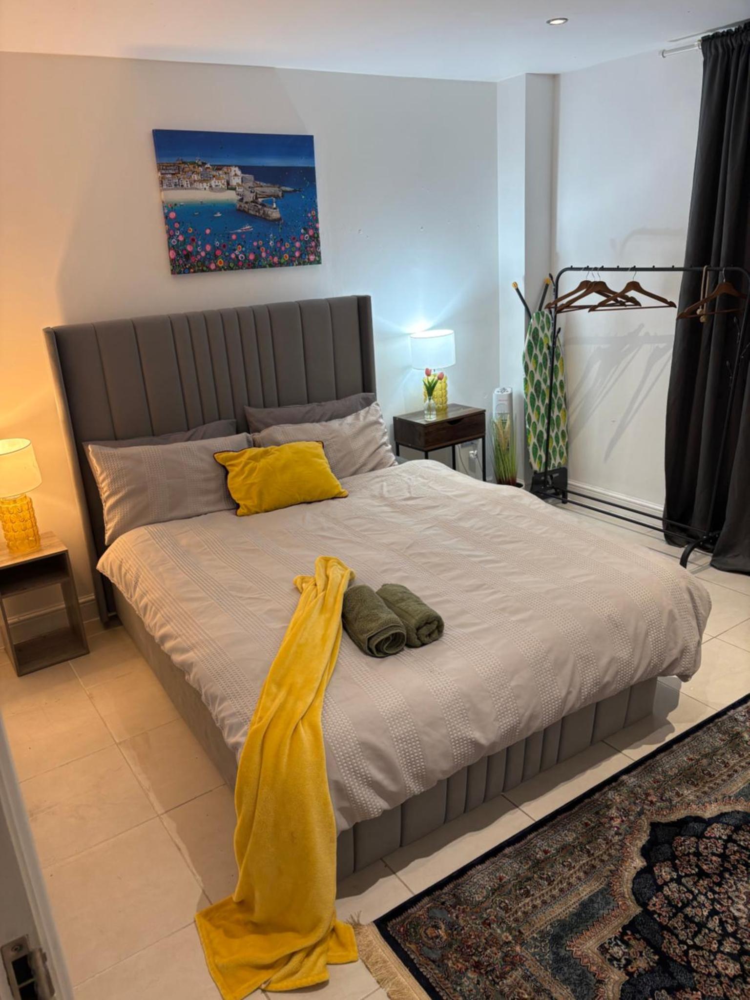 a bedroom with a large bed with yellow sheets at Tower Bridge Luxury Apartment with Balcony in London
