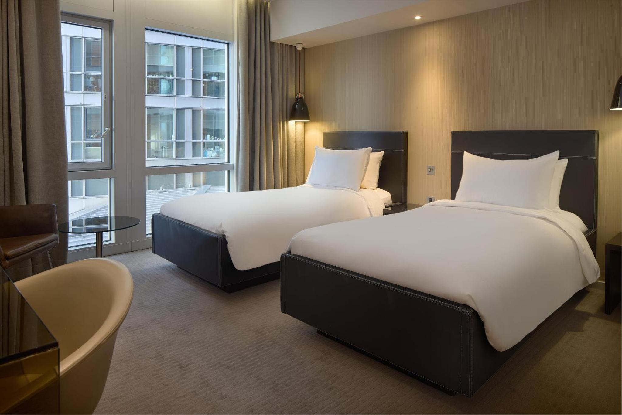 a hotel room with two beds and a window at Radisson Blu Hotel, London Canary Wharf East in London