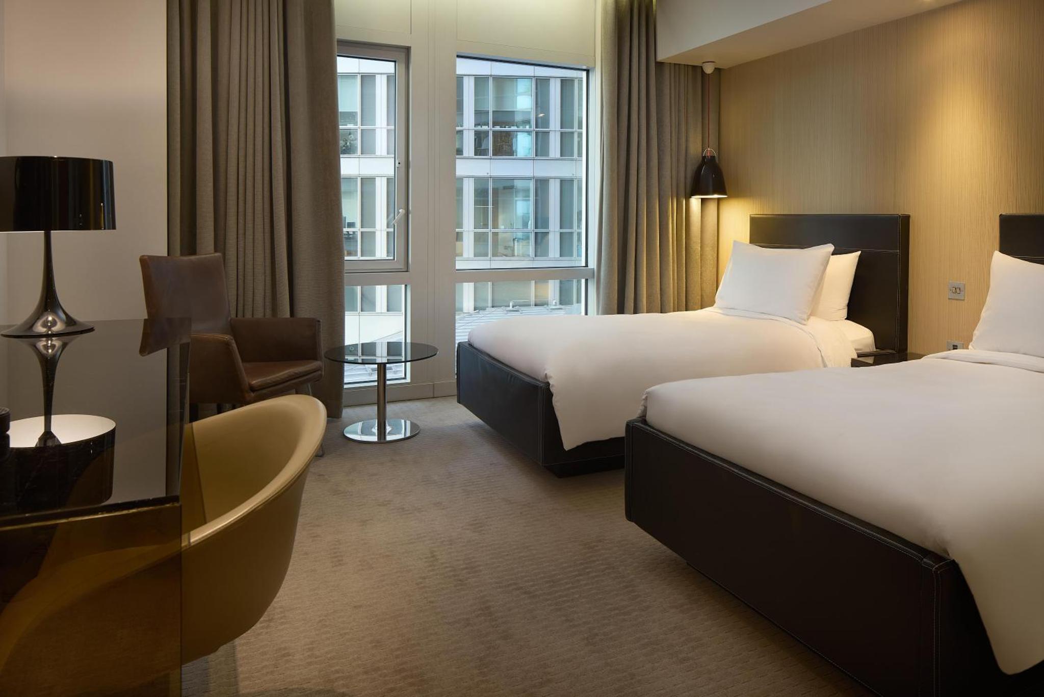 a hotel room with two beds and a window at Radisson Blu Hotel, London Canary Wharf East in London +100 photos