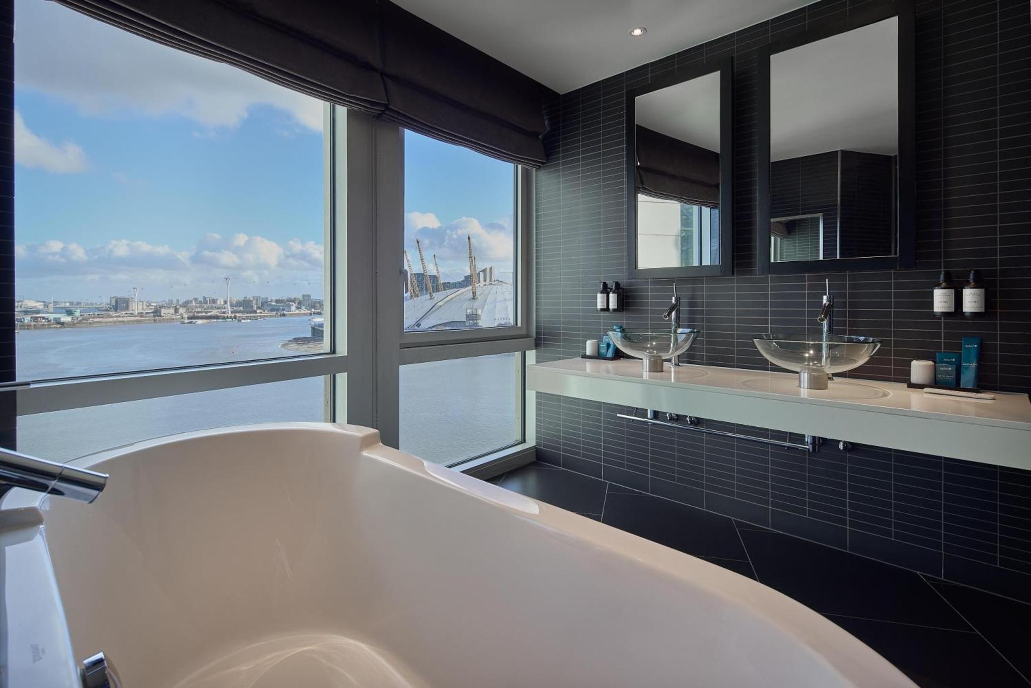 a bathroom with a tub and a large window at Radisson Blu Hotel, London Canary Wharf East in London