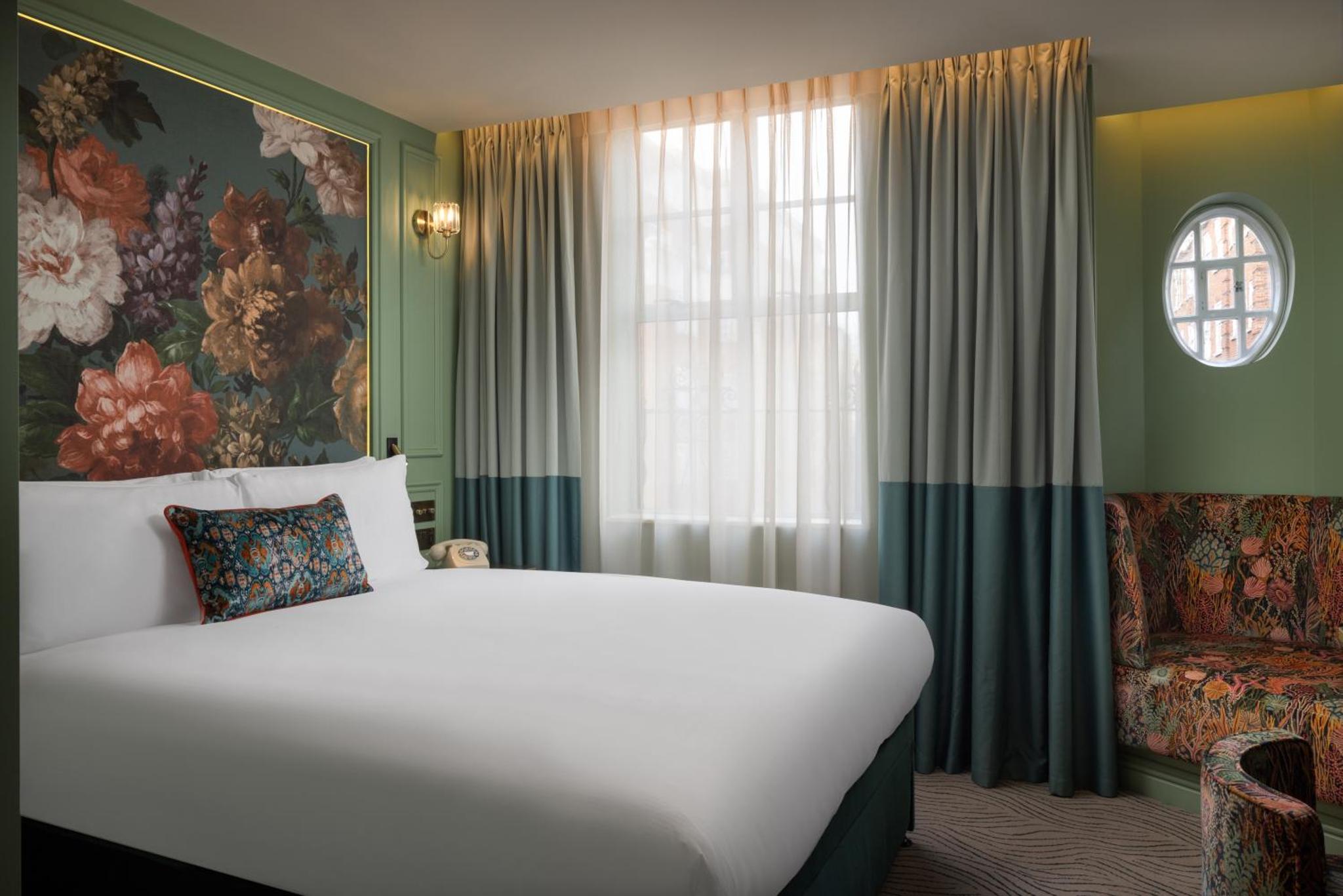 a bedroom with a large white bed and a window at The Kensington Hideaway in London