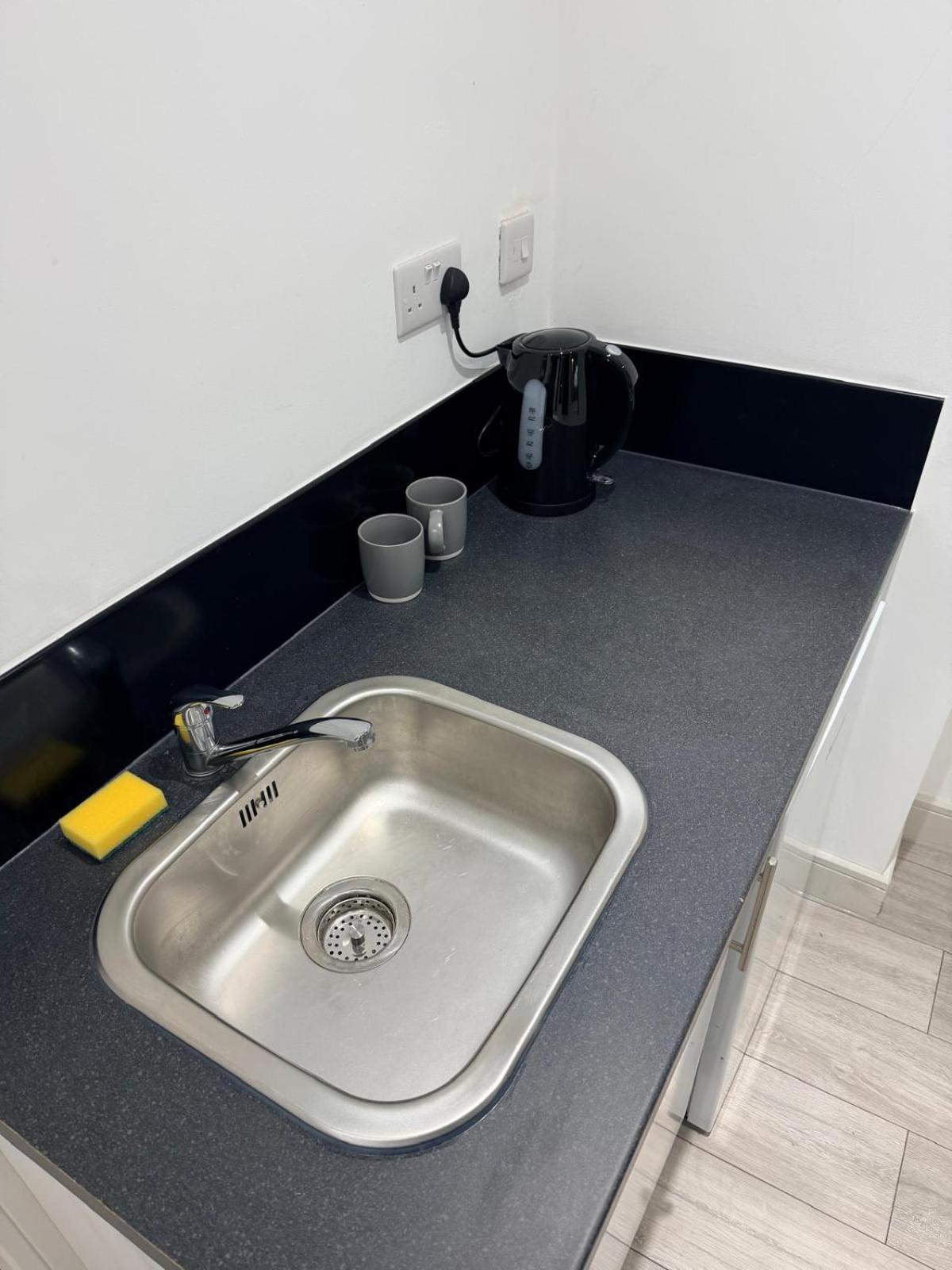 a kitchen counter with a sink in a kitchen at Modern Studios Elephant and Castle in London +6 photos