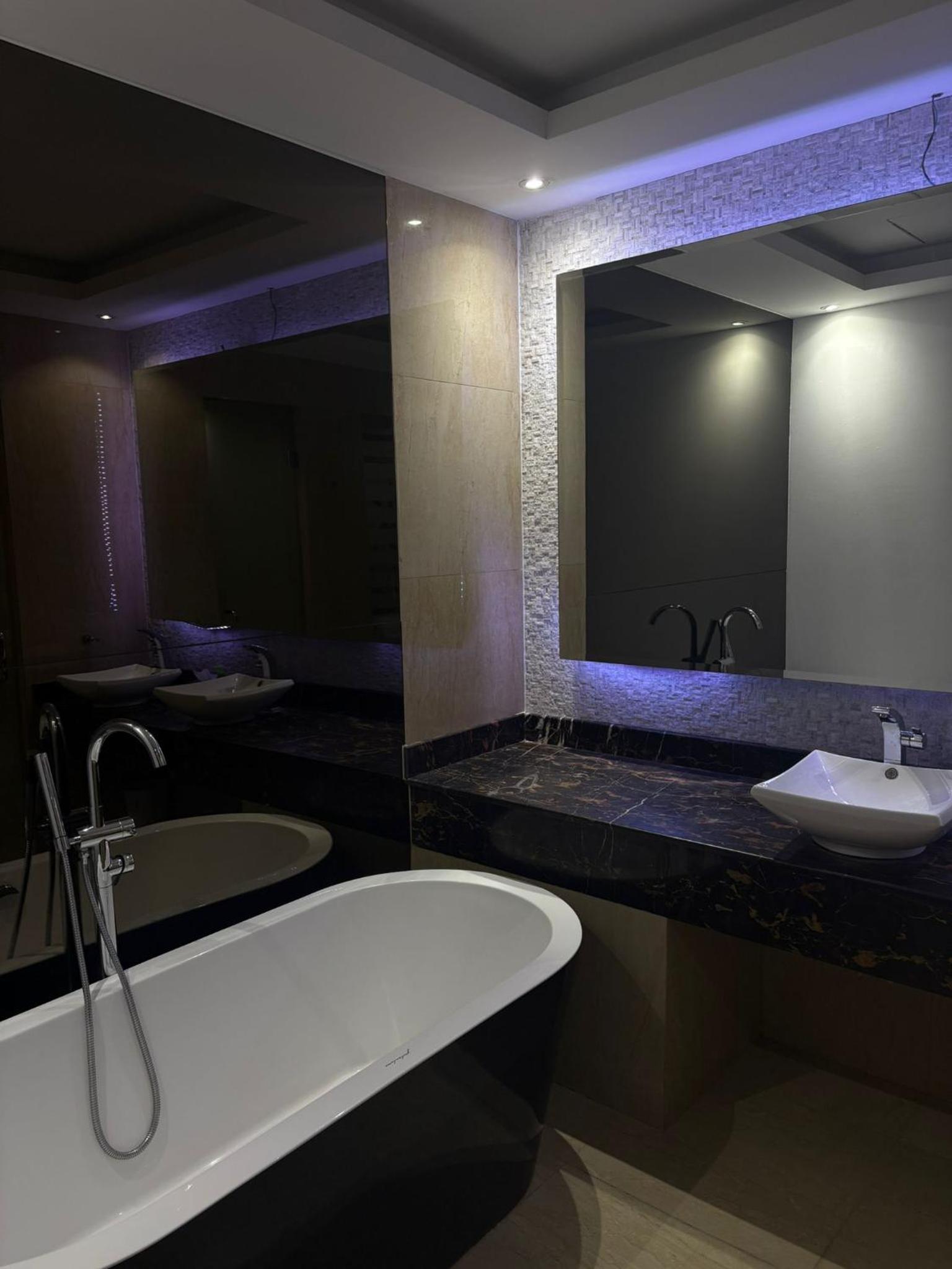 a bathroom with a bath tub and a sink at شقة فخمة بإطلالة بحرية في امواج in Muharraq