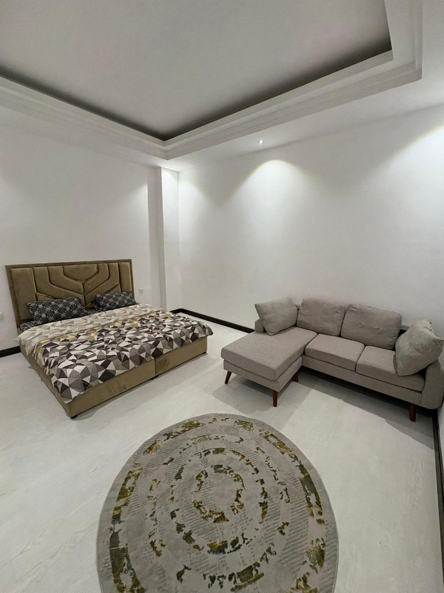 a living room with a couch and a bed and a rug at شقة فخمة بإطلالة بحرية في امواج in Muharraq