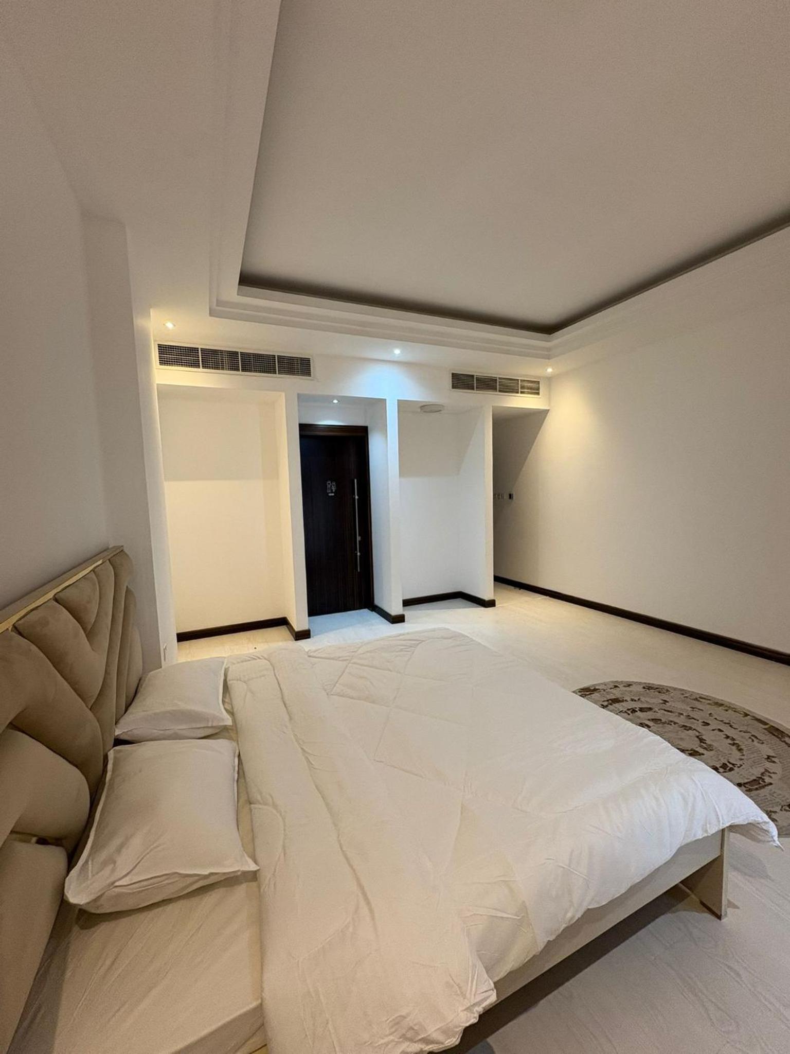 a bedroom with a large white bed and a couch at شقة فخمة بإطلالة بحرية في امواج in Muharraq +8 photos
