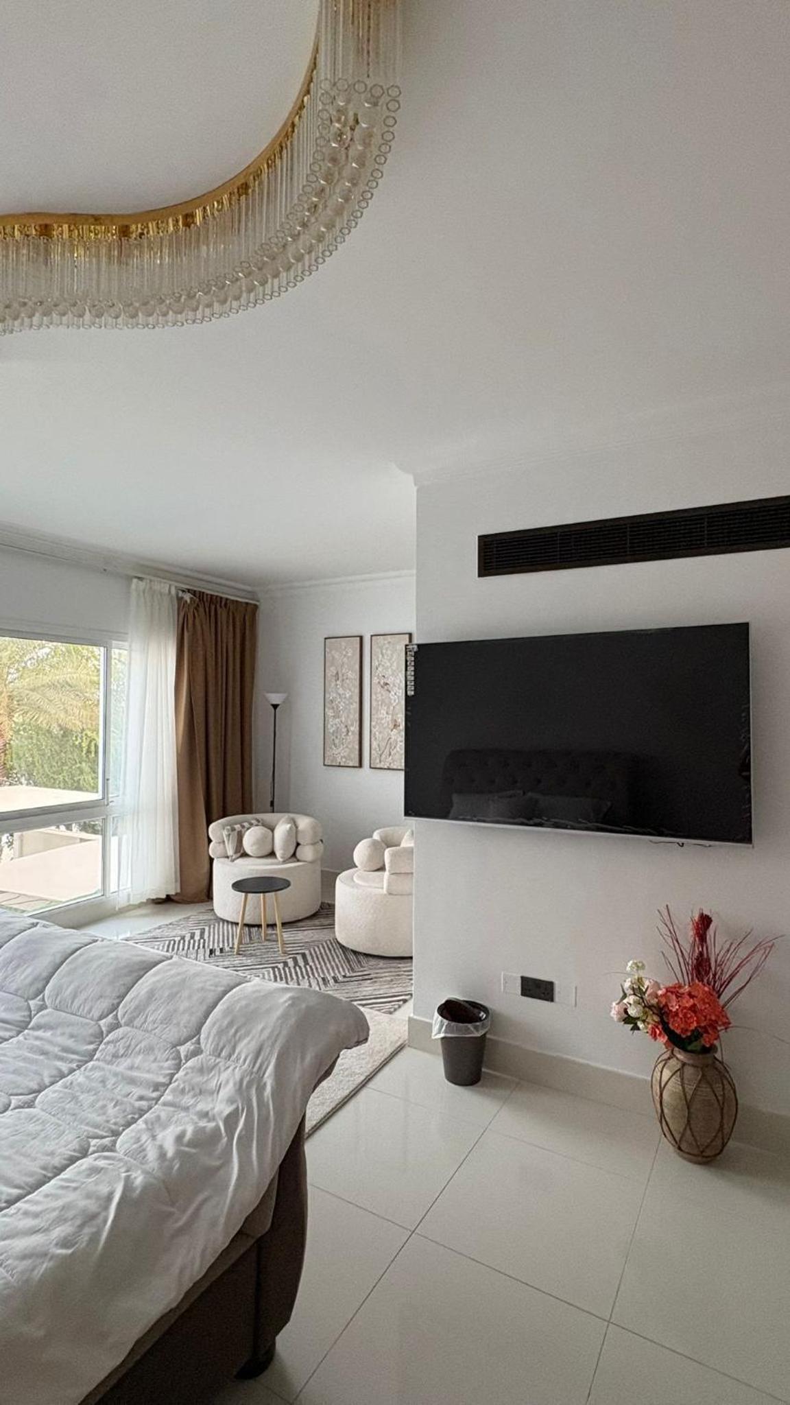 a white bedroom with a large bed and a fireplace at شالية Vipمرسى البحرين 4 غرف مسبح خاص وشاطى in Muharraq